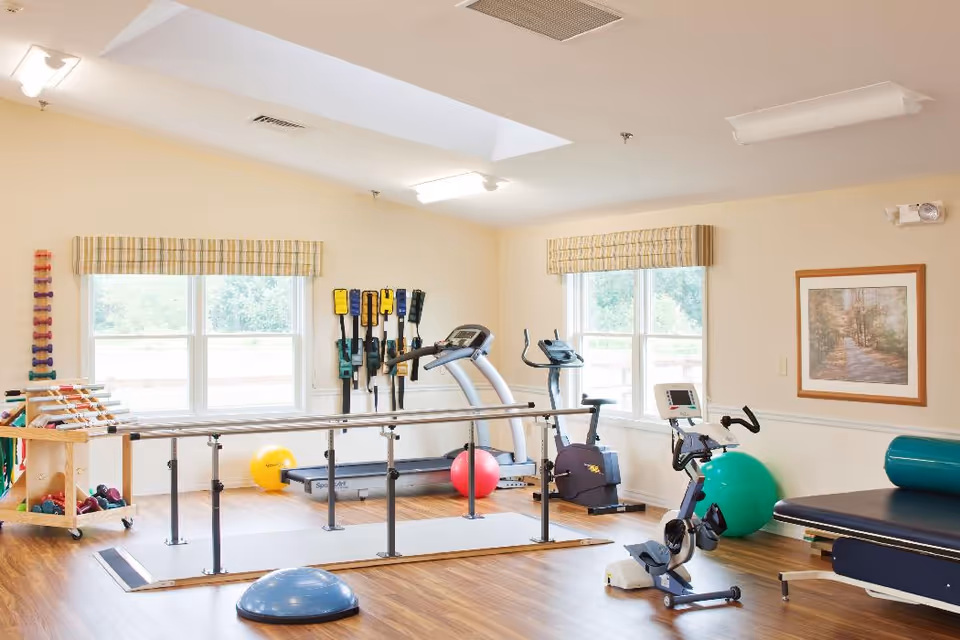 A fitness area in a senior living facility with exercise equipment and therapy tools.