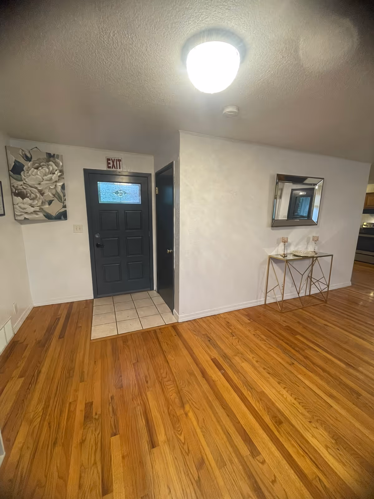 Interior entry hall with hardwood floors, a dark front door, and a decorative console table.