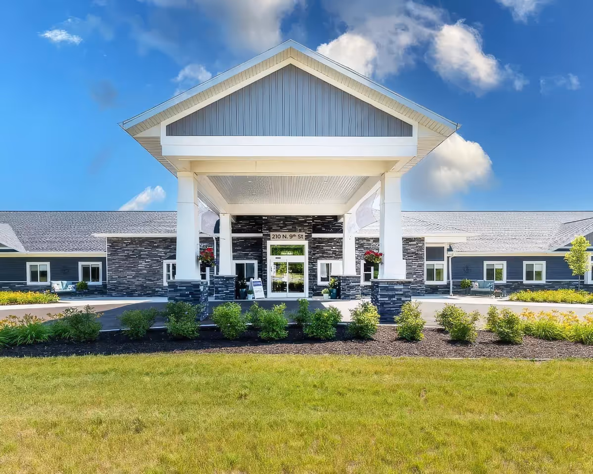 Exterior view of Provision Living at Oshtemo entrance with a covered portico and landscaped grounds.
