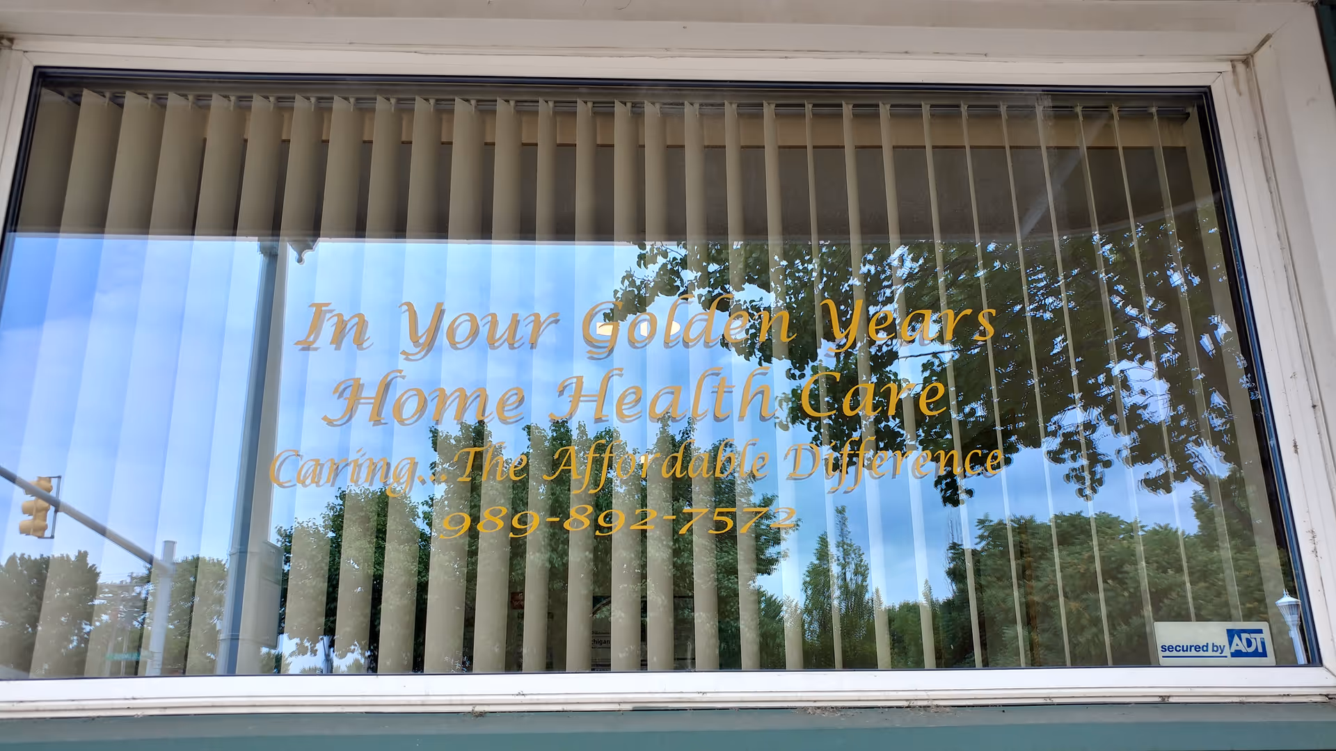 A storefront window displays gold signage for In Your Golden Years Home Health Care with blinds