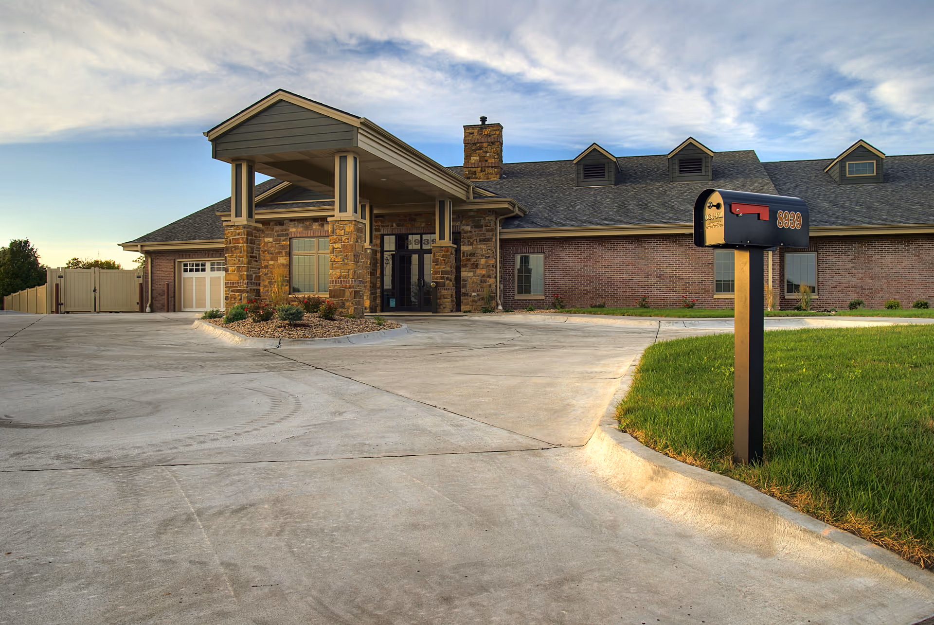 Waterford at Wilderness Hills facility exterior with brick facade, driveway, and mailbox.