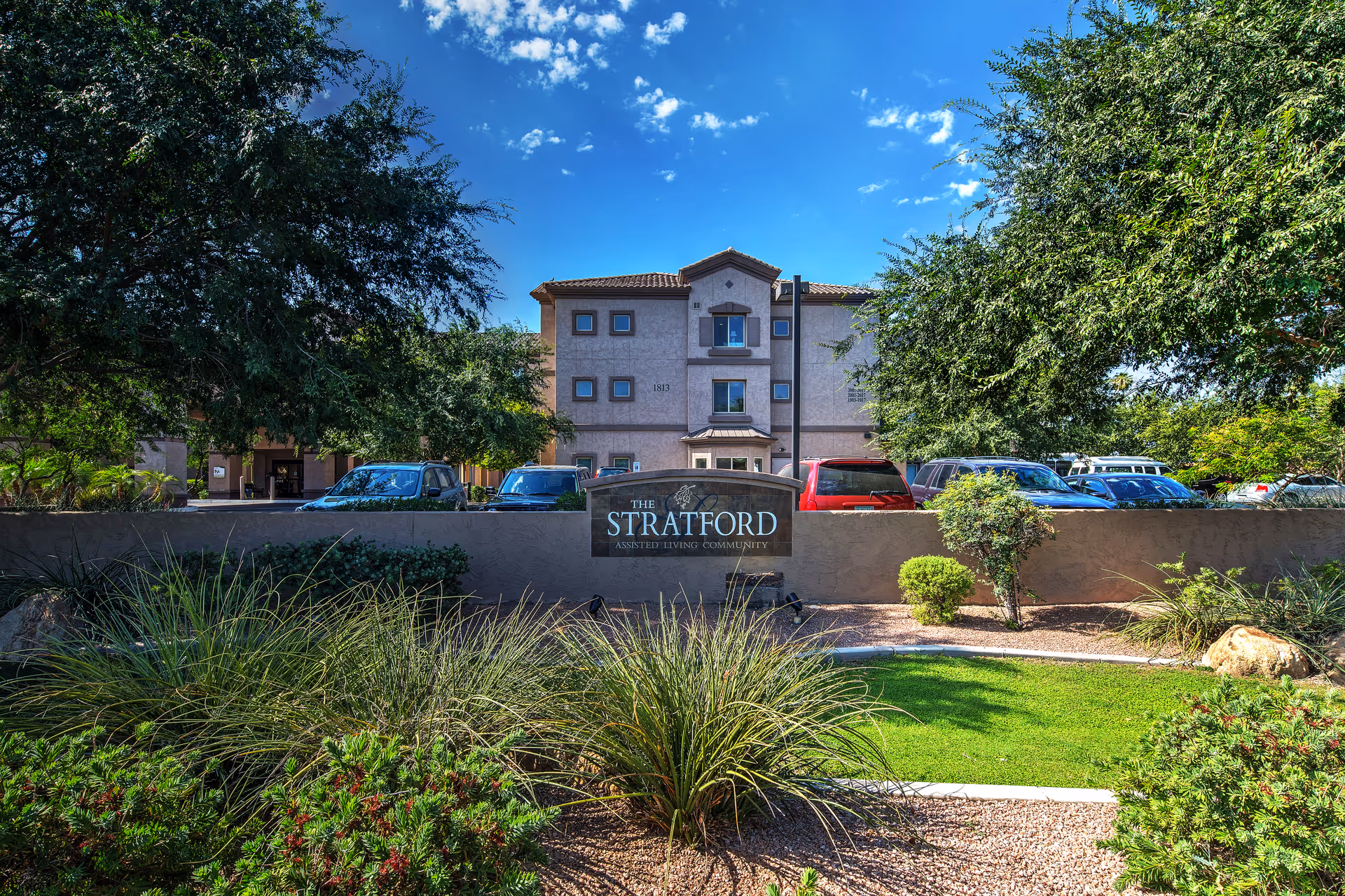 Front view of Ridge at the Stratford senior living building with sign and parked cars.
