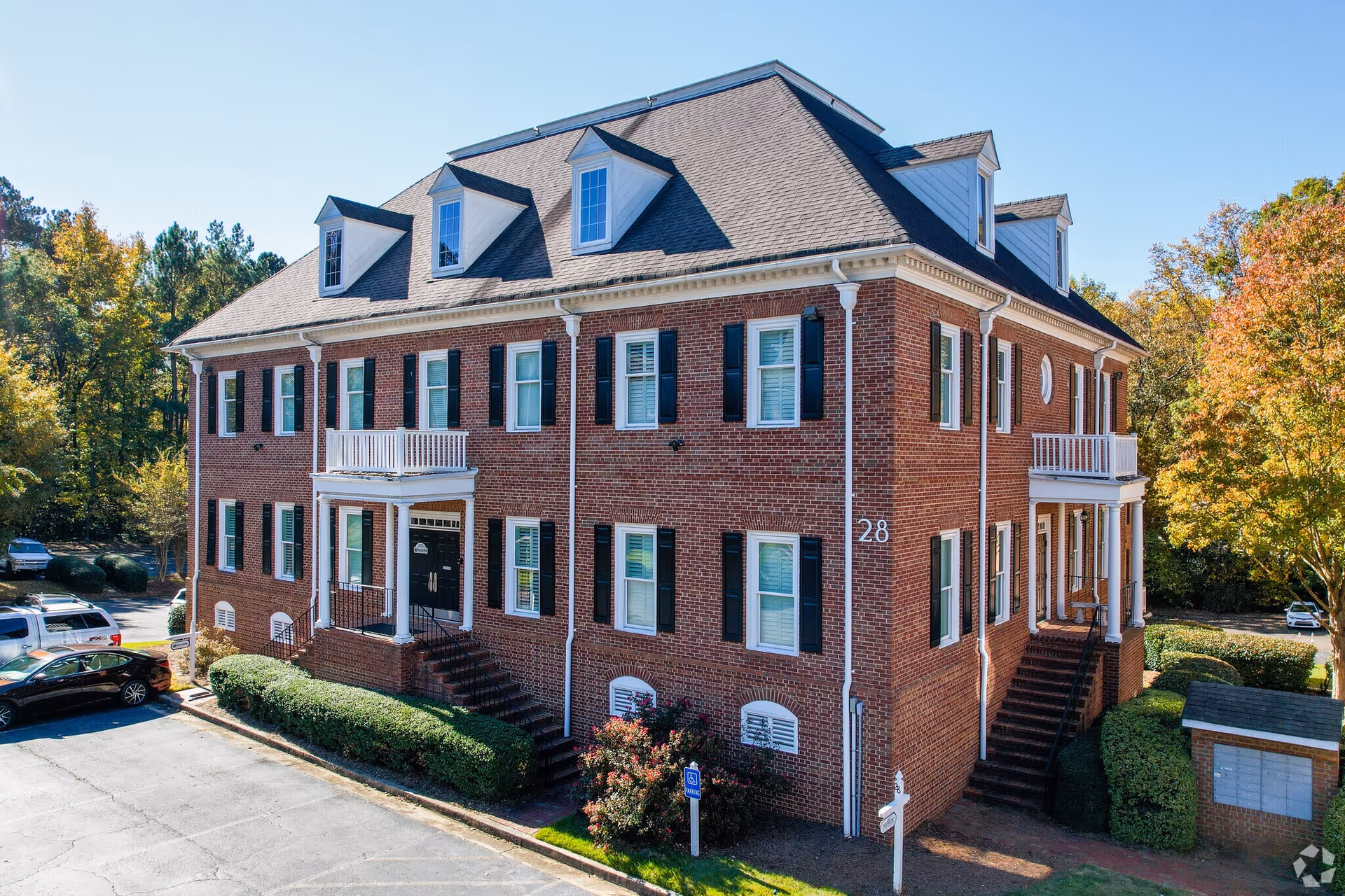 Exterior view of a brick senior living building with stairs and greenery
