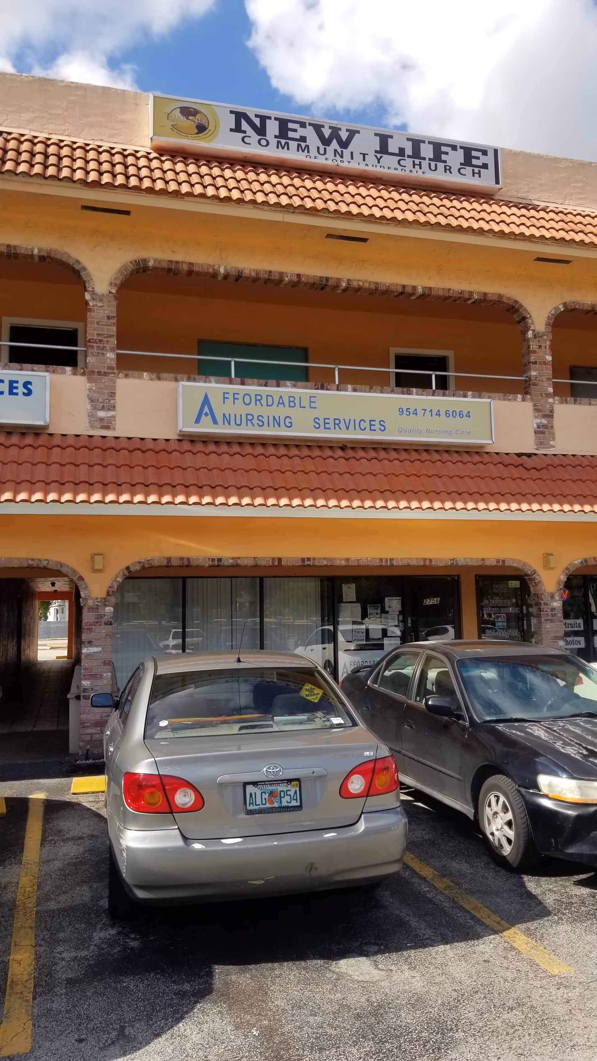 Exterior of a two-story building with Affordable Nursing Services sign and parked cars.
