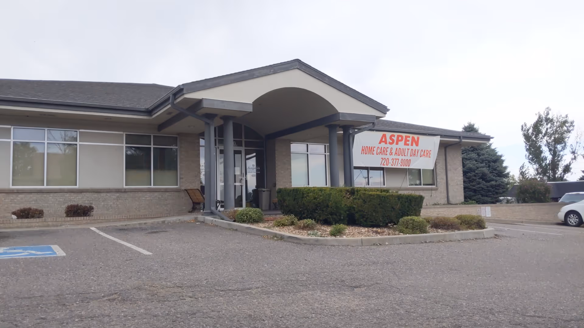Front view of Aspen healthcare facility with parking and curved entrance awning.