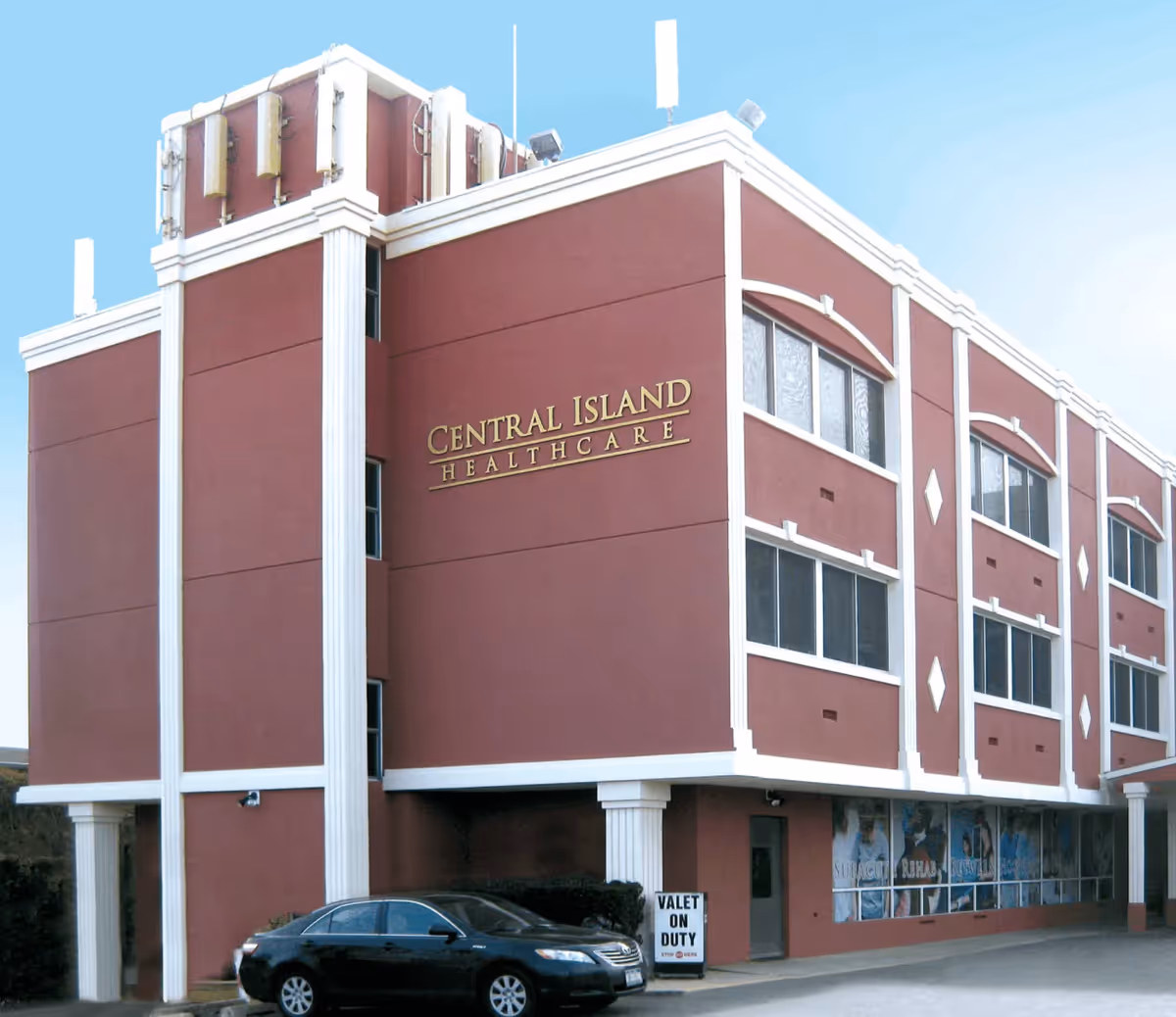 Front exterior of Central Island Healthcare building with a parked black car