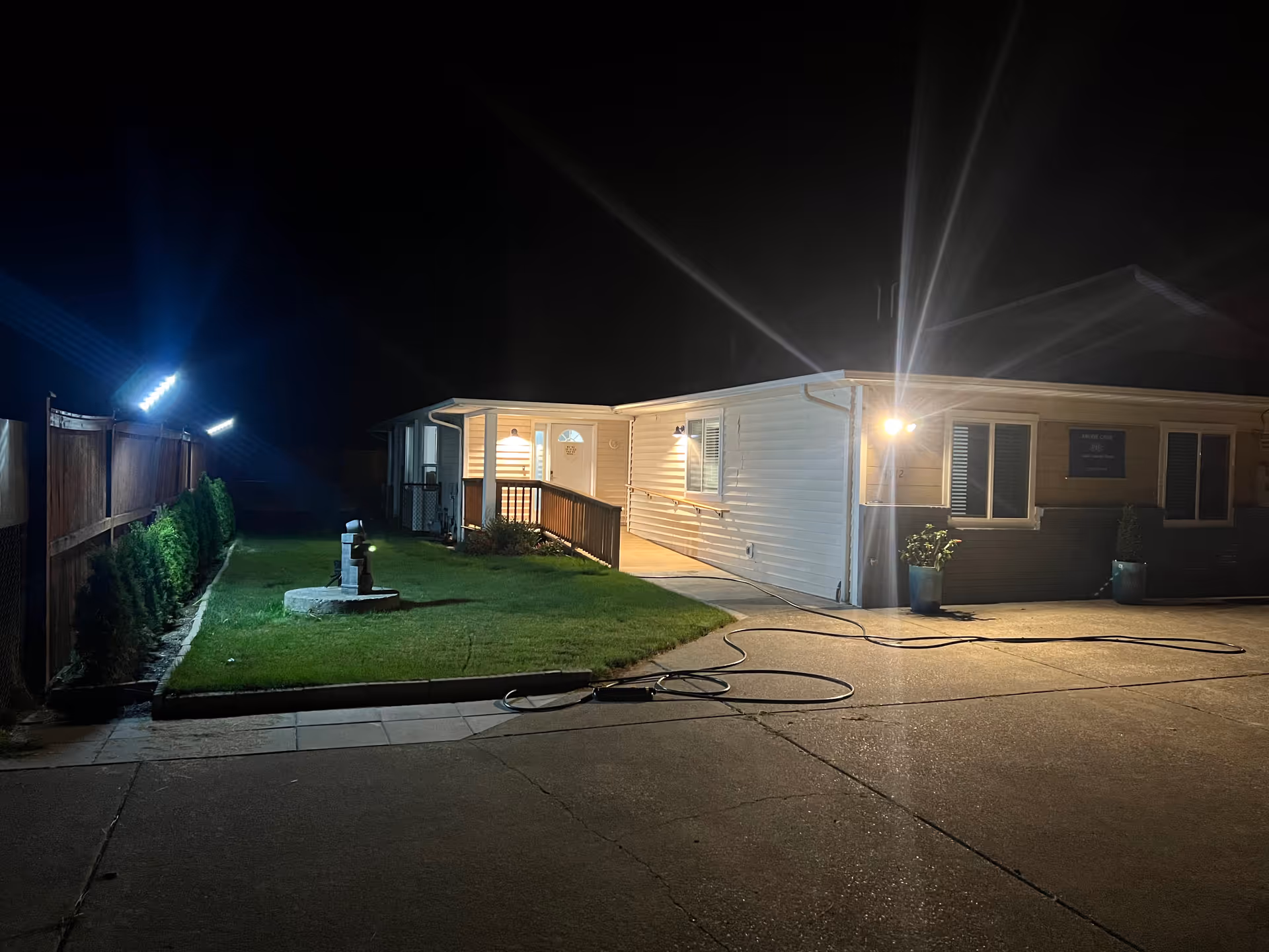 Night exterior of a single-story senior living facility with a lit front entrance.
