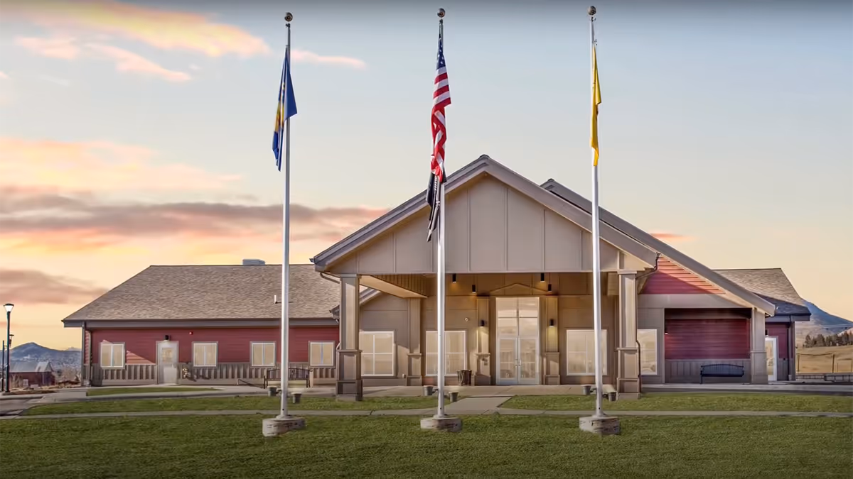 Front view of a single-story facility with flagpoles and a covered entrance.