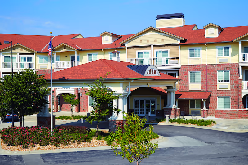 Exterior view of Shawnee Hills senior living facility with a covered entrance and red roof.