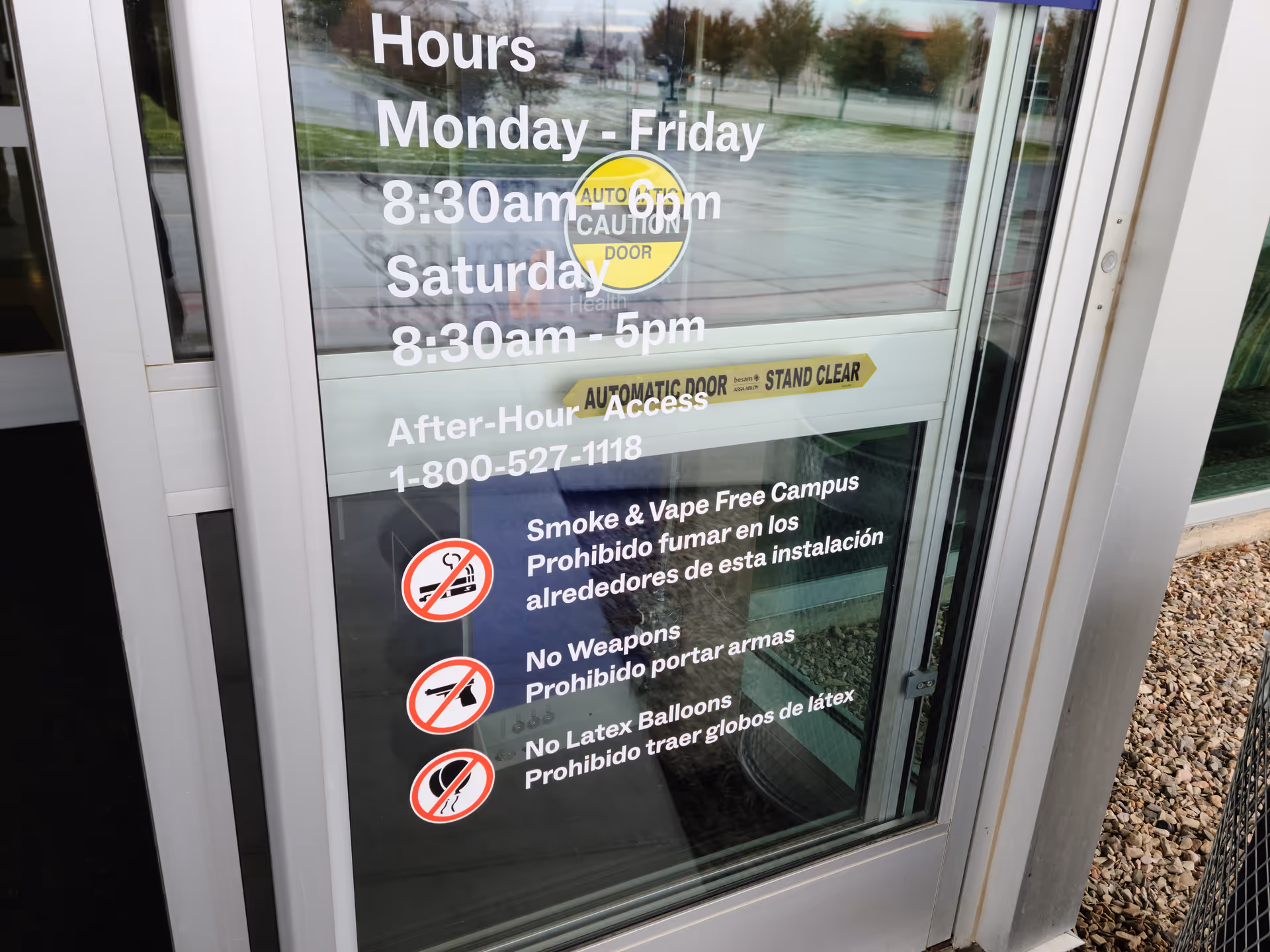 Glass entry door displays hours, rules, and warnings at Intermountain Homecare and Hospice entrance.