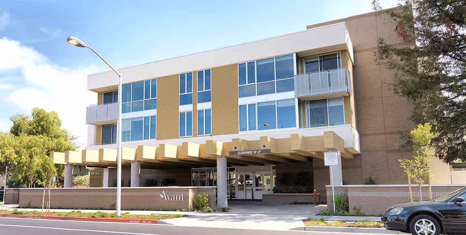 Front exterior of a multi-story senior living building with an entrance canopy and 'The Avant' signage.