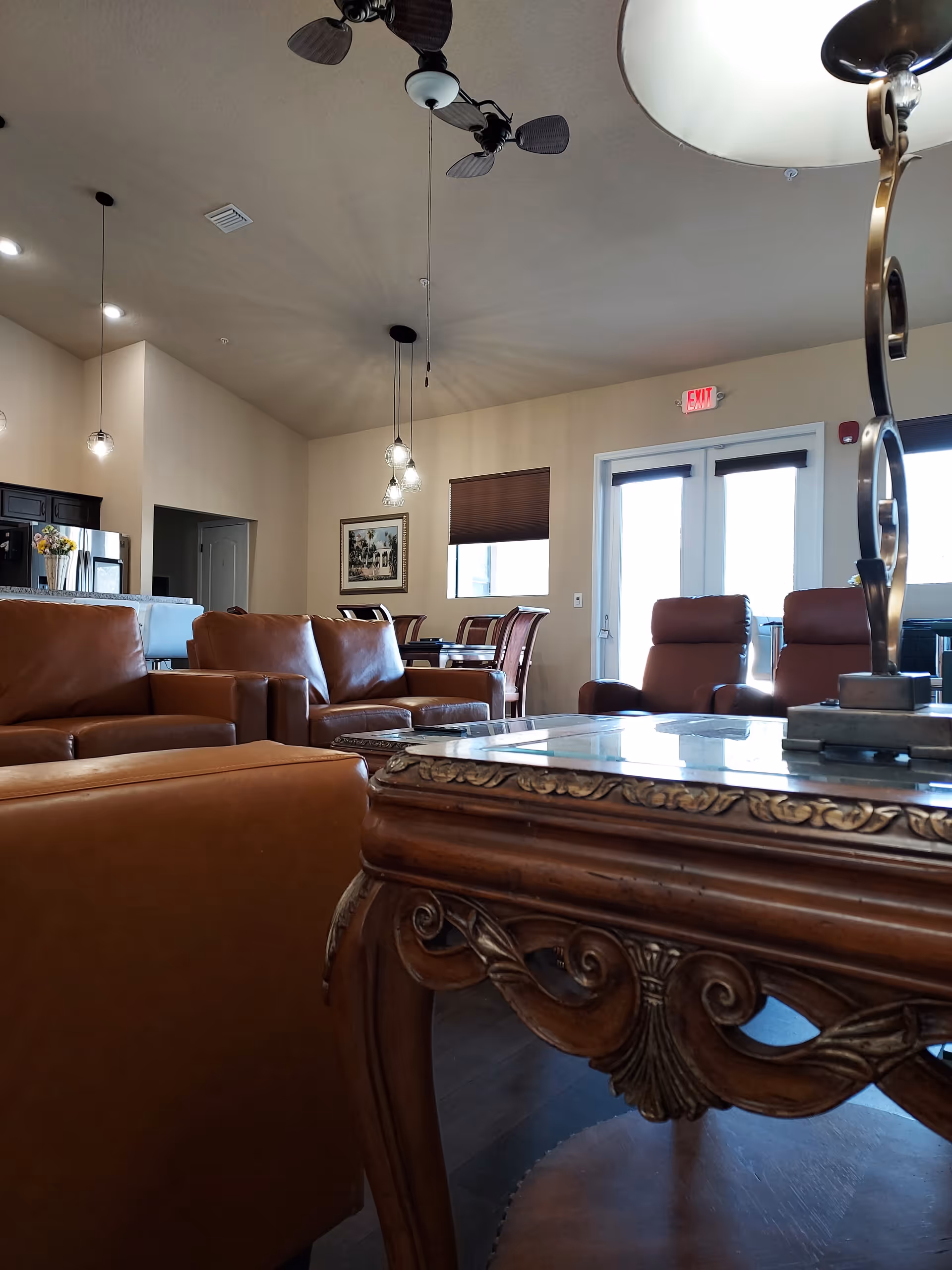 Spacious lounge in Casalia Gardens with leather seating, ornate coffee table, and warm lighting.