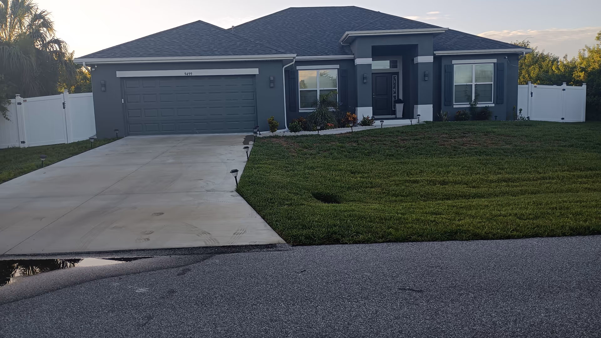 Front exterior of a gray single-story home with a two-car garage and green lawn.