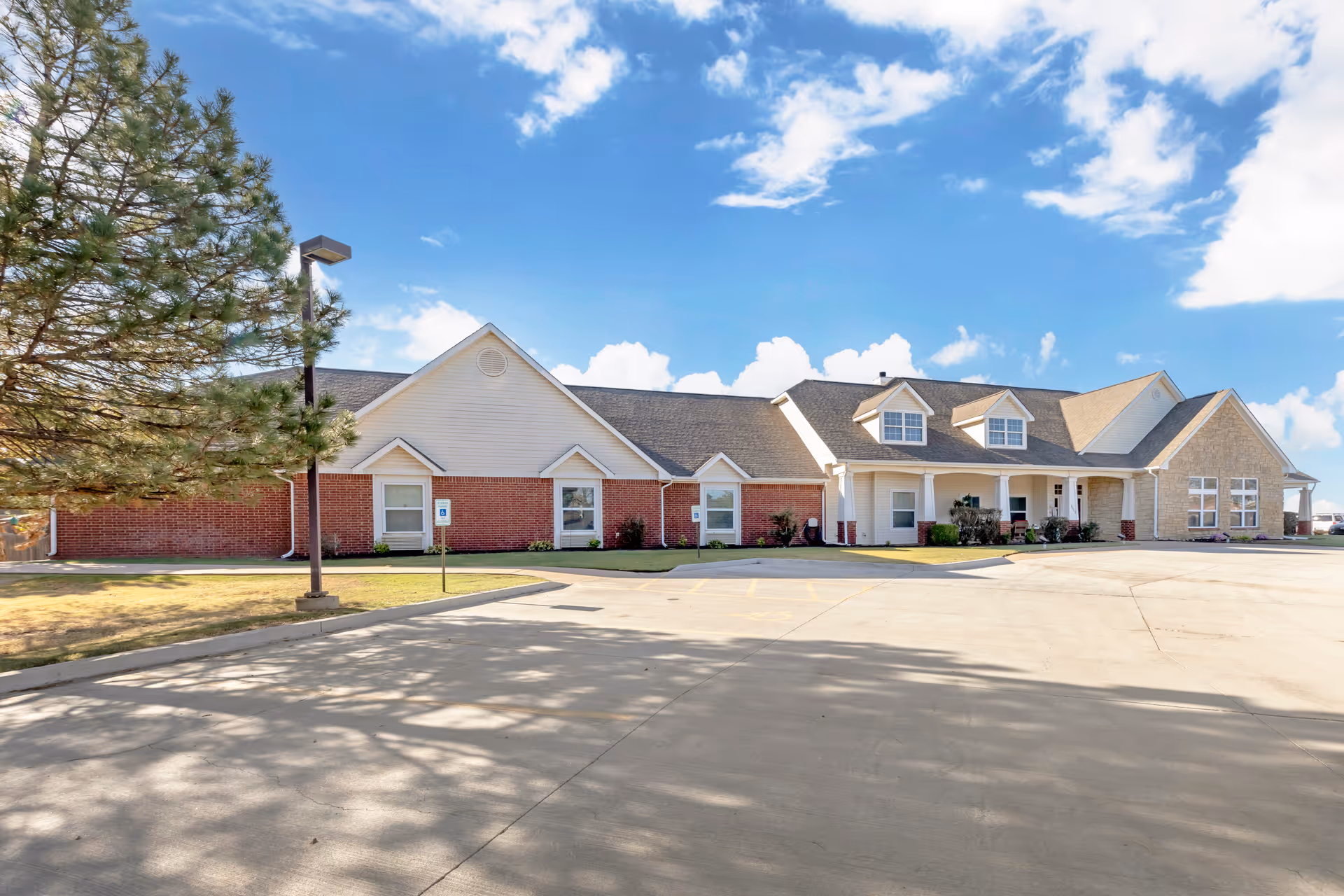 Front exterior of Brookdale Enid, a single-story facility with brick and beige siding.