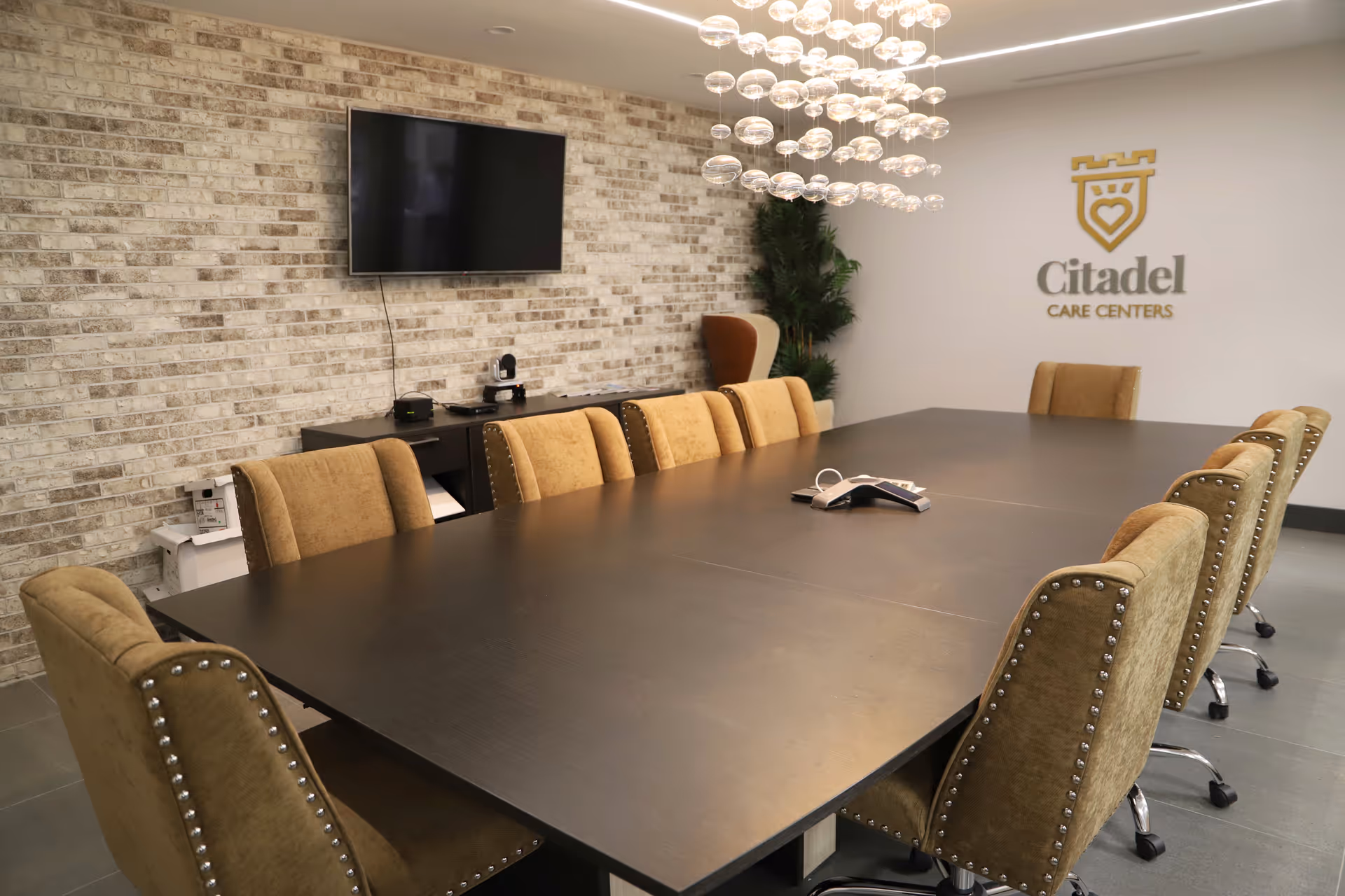 Large conference table with beige chairs in a Citadel Care Centers meeting room.
