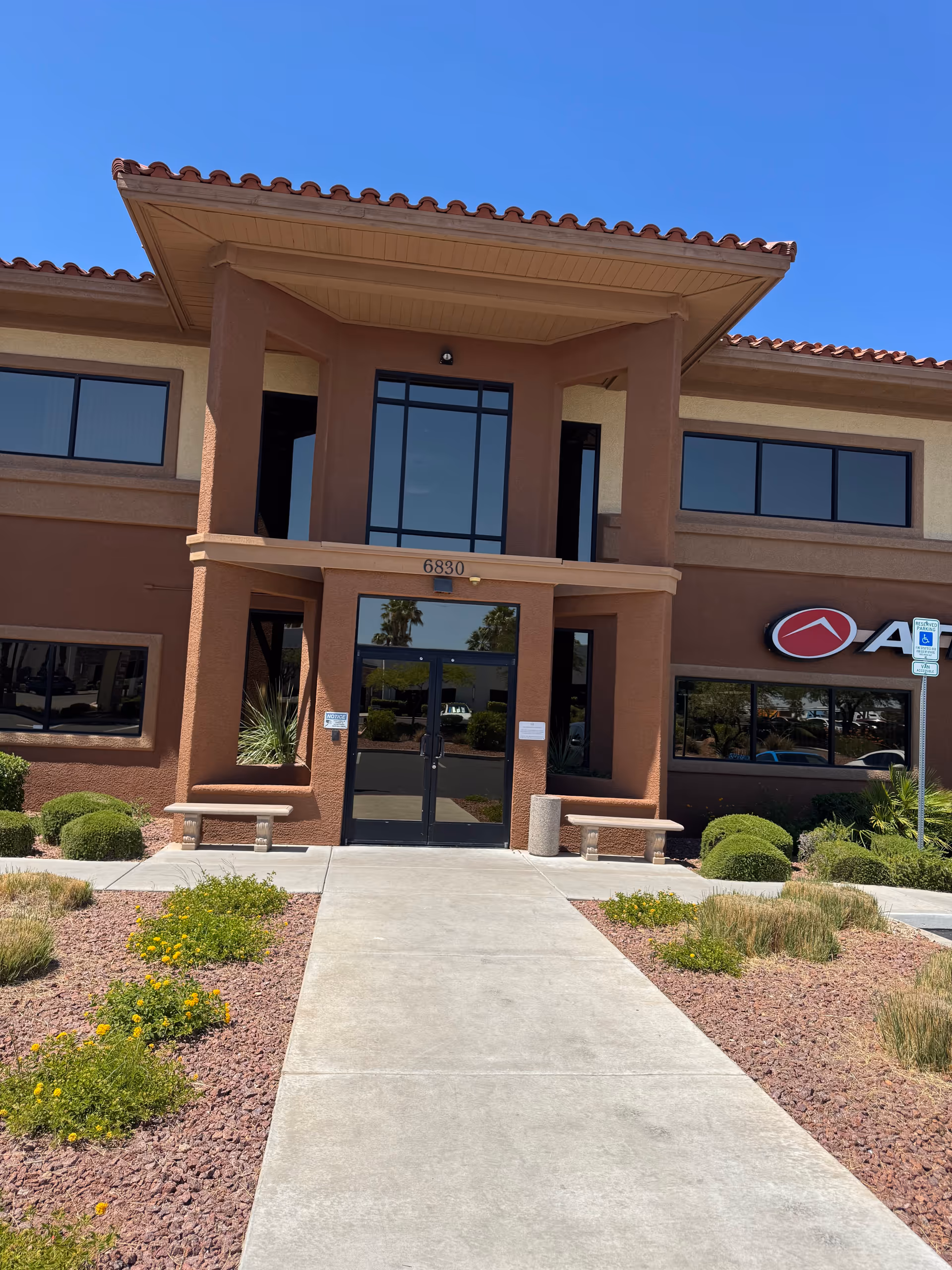 Facade of Haven Personal Care Services facility with glass entrance doors and desert landscaping