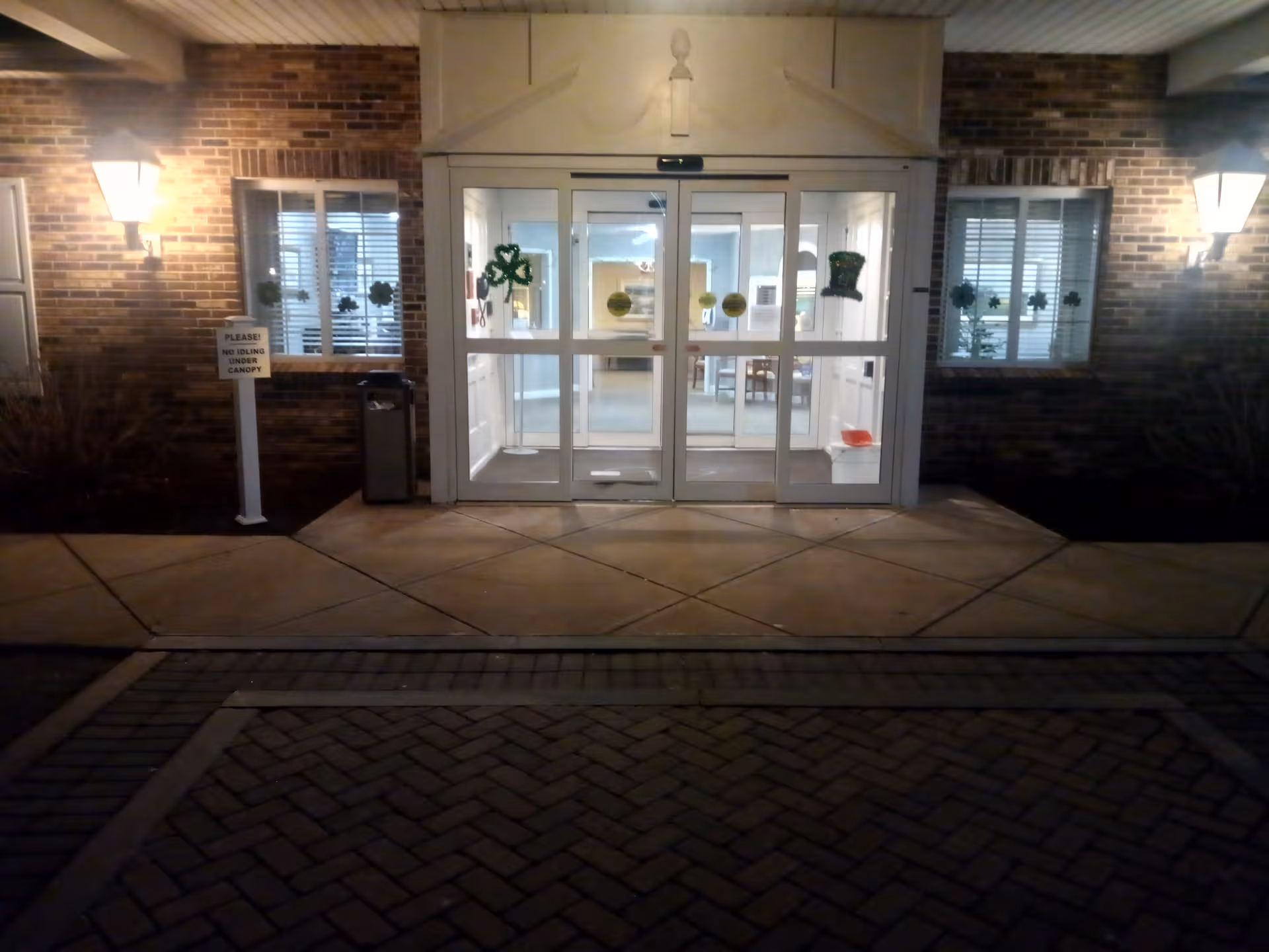 Night exterior of Chestnut Hill of East Longmeadow, glass entrance doors, brick facade.