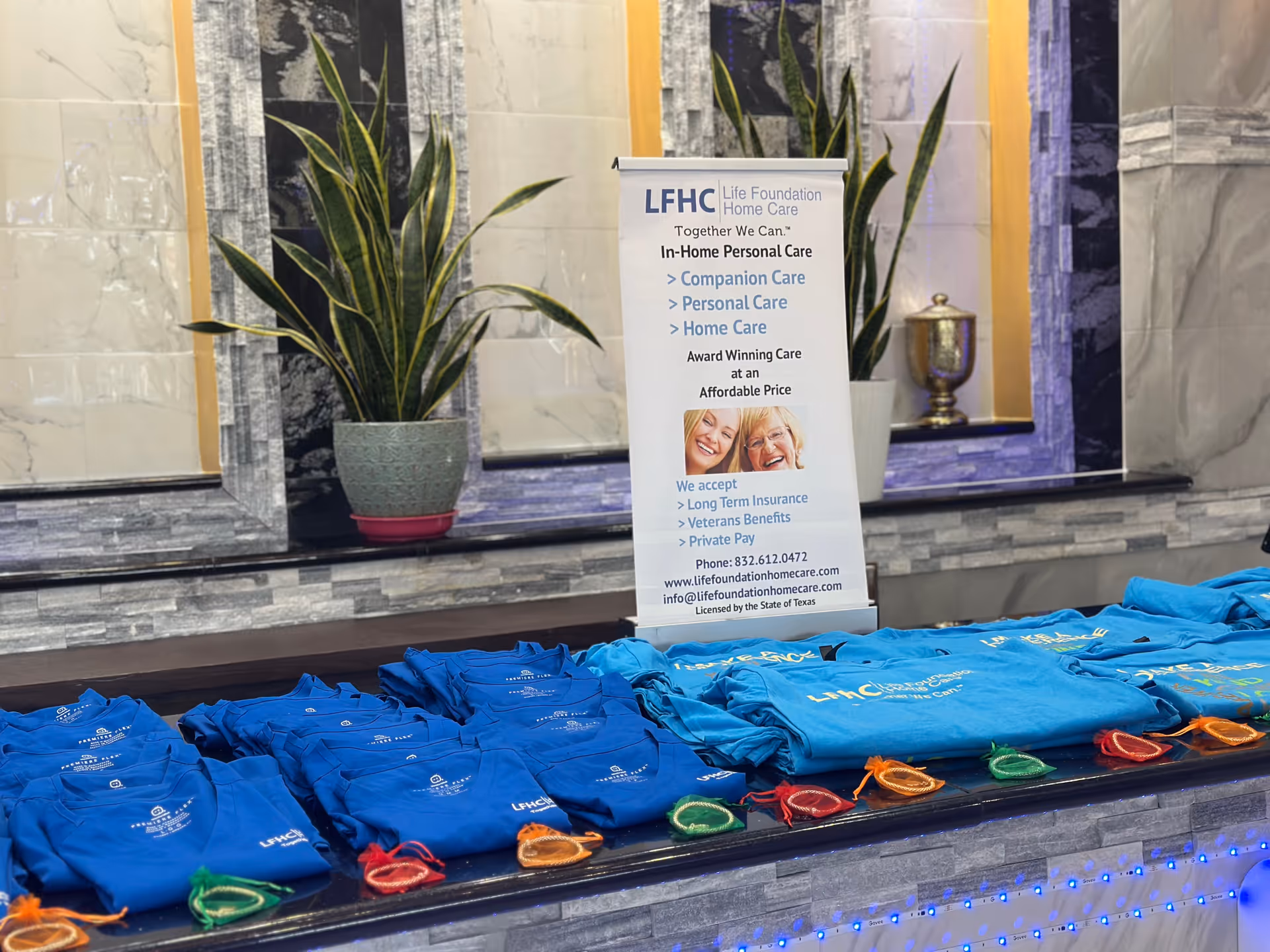 Indoor lobby area with Life Foundation Home Care banner and blue t-shirts on a counter