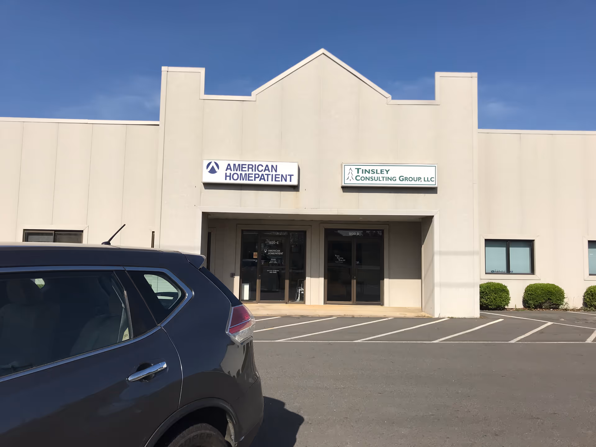 Front view of a beige commercial building with American HomePatient sign.