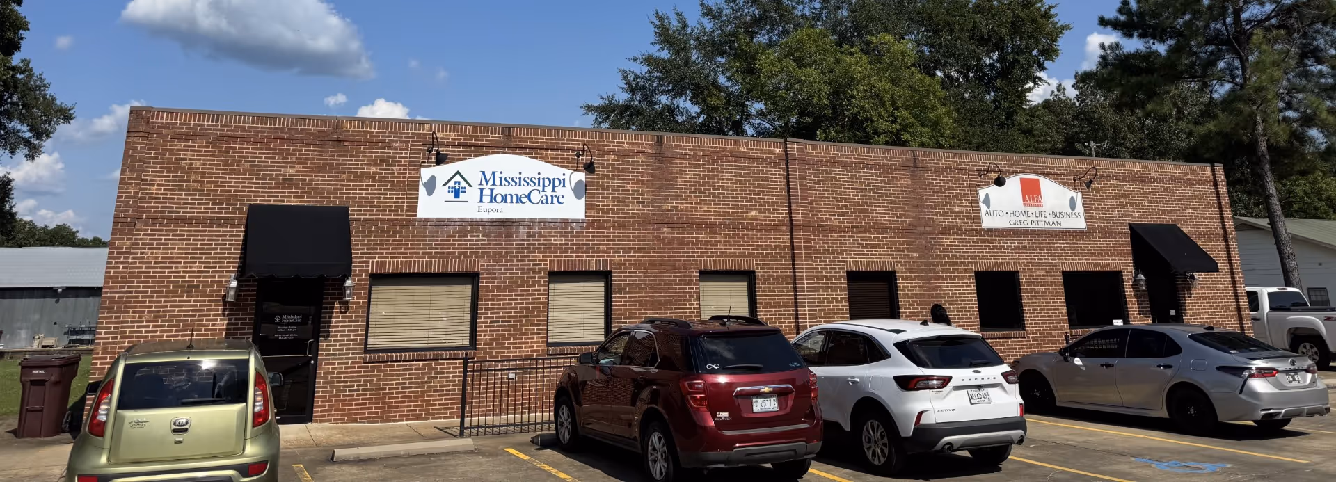 Brick storefront of Mississippi HomeCare Eupora with several parked cars outside.