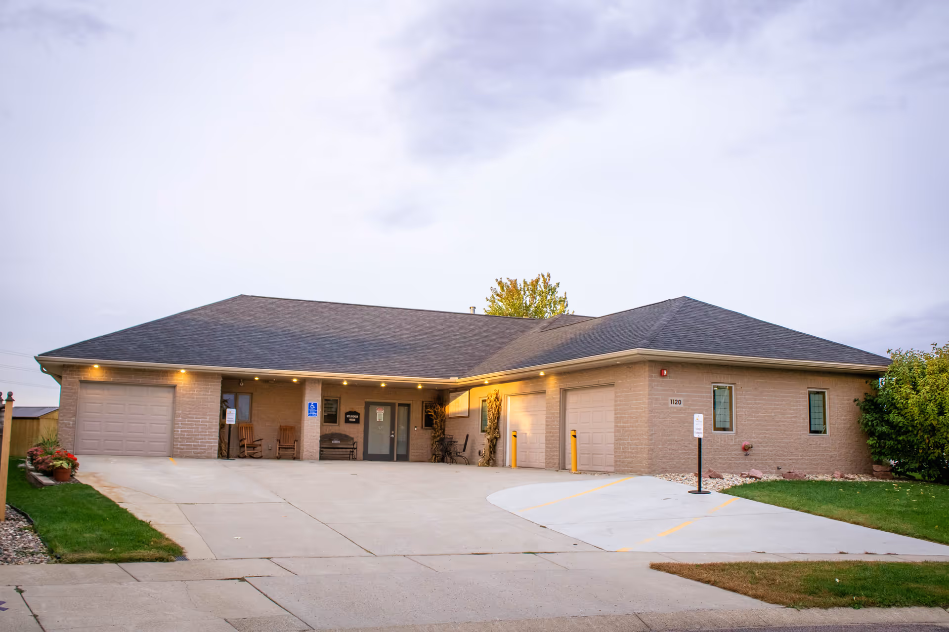 Front exterior of a brick hospice facility with driveway and entrance.