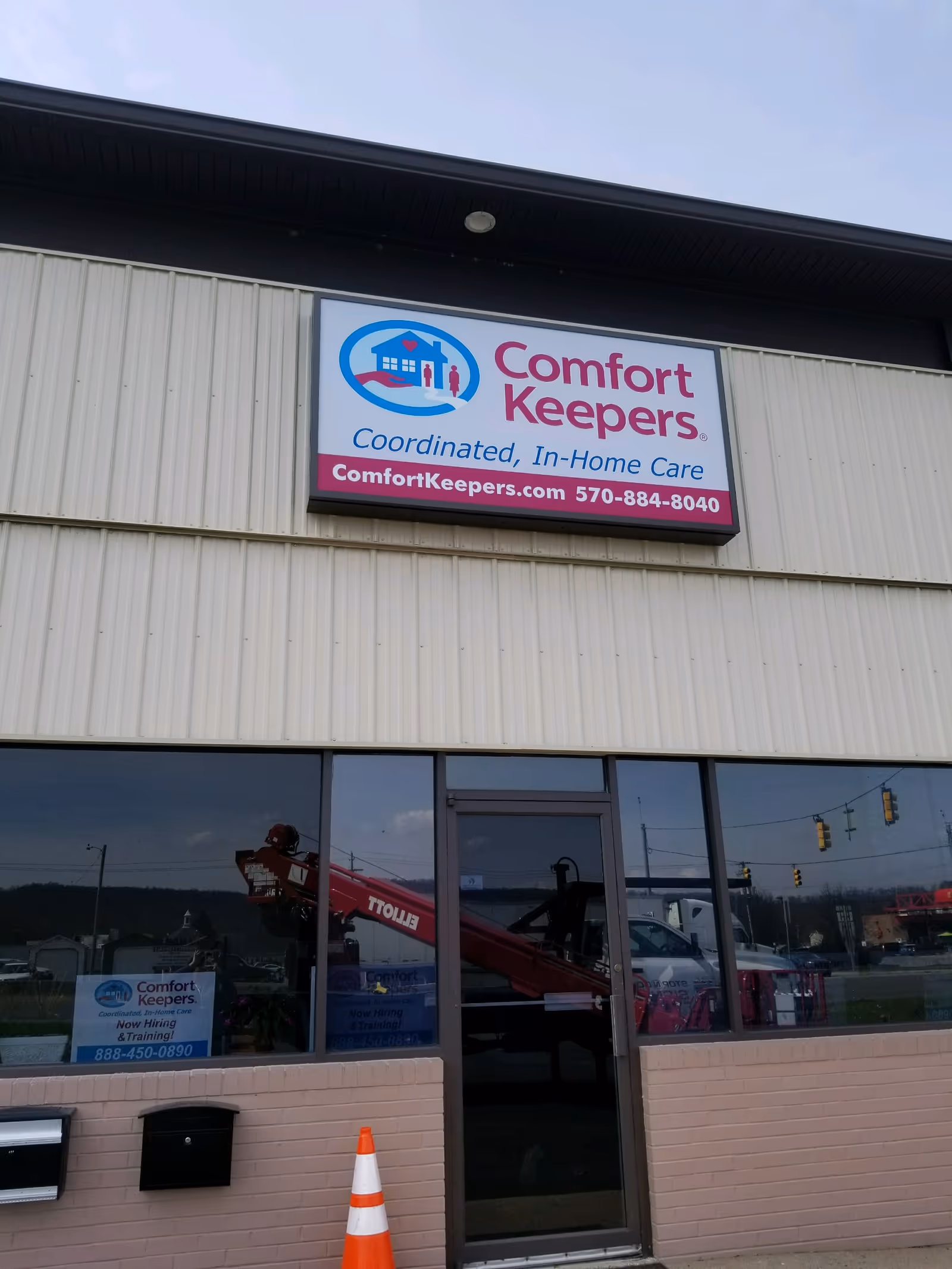 Exterior view of Comfort Keepers building with sign and glass entry door.