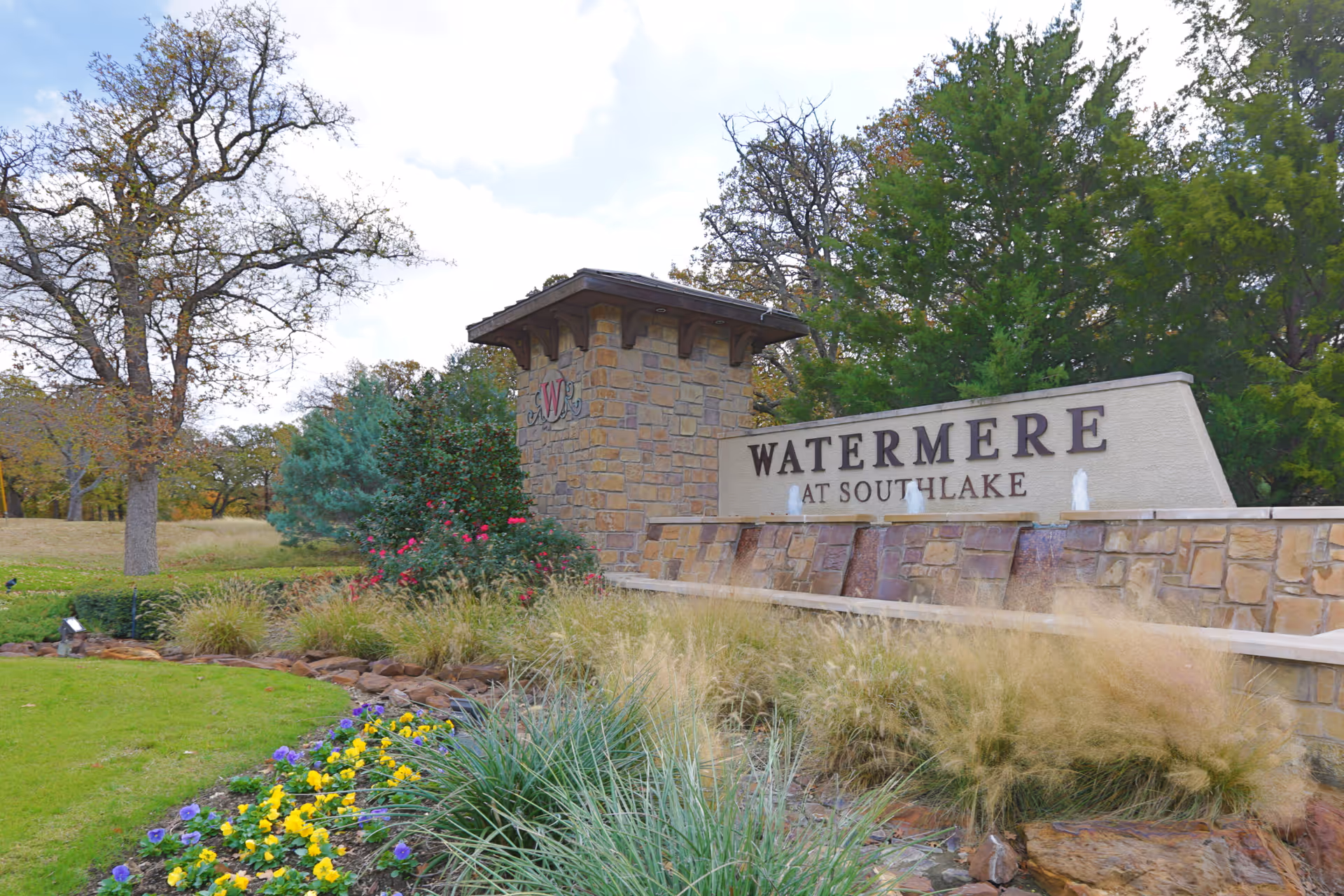 Stone entrance sign for Watermere at Southlake with surrounding landscaping.