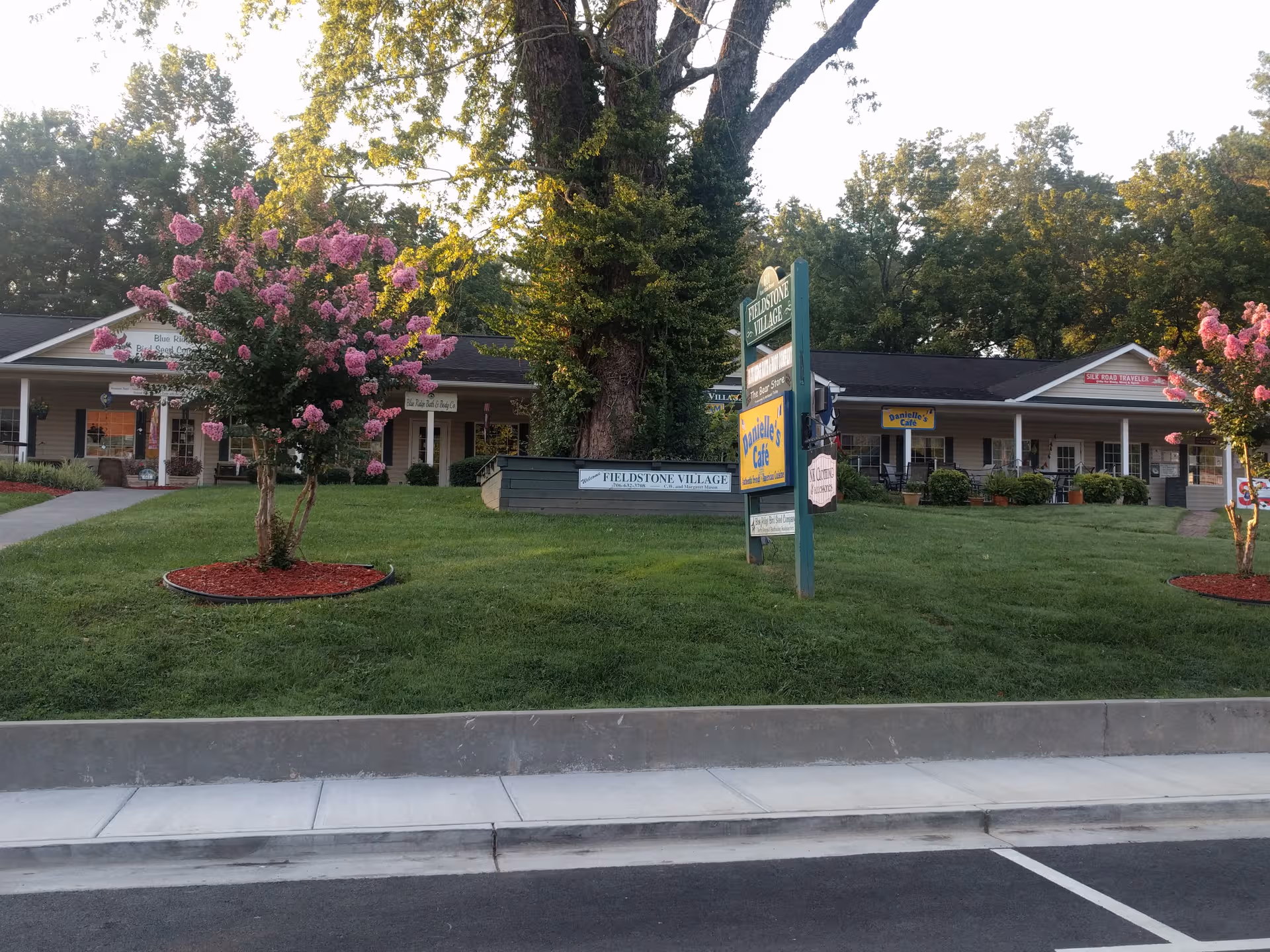 Fieldstone Village senior living campus with manicured lawn, flowering trees, and a central sign.