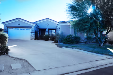 Desert Sky's senior living facility exterior with a driveway, entrance, and landscaping.