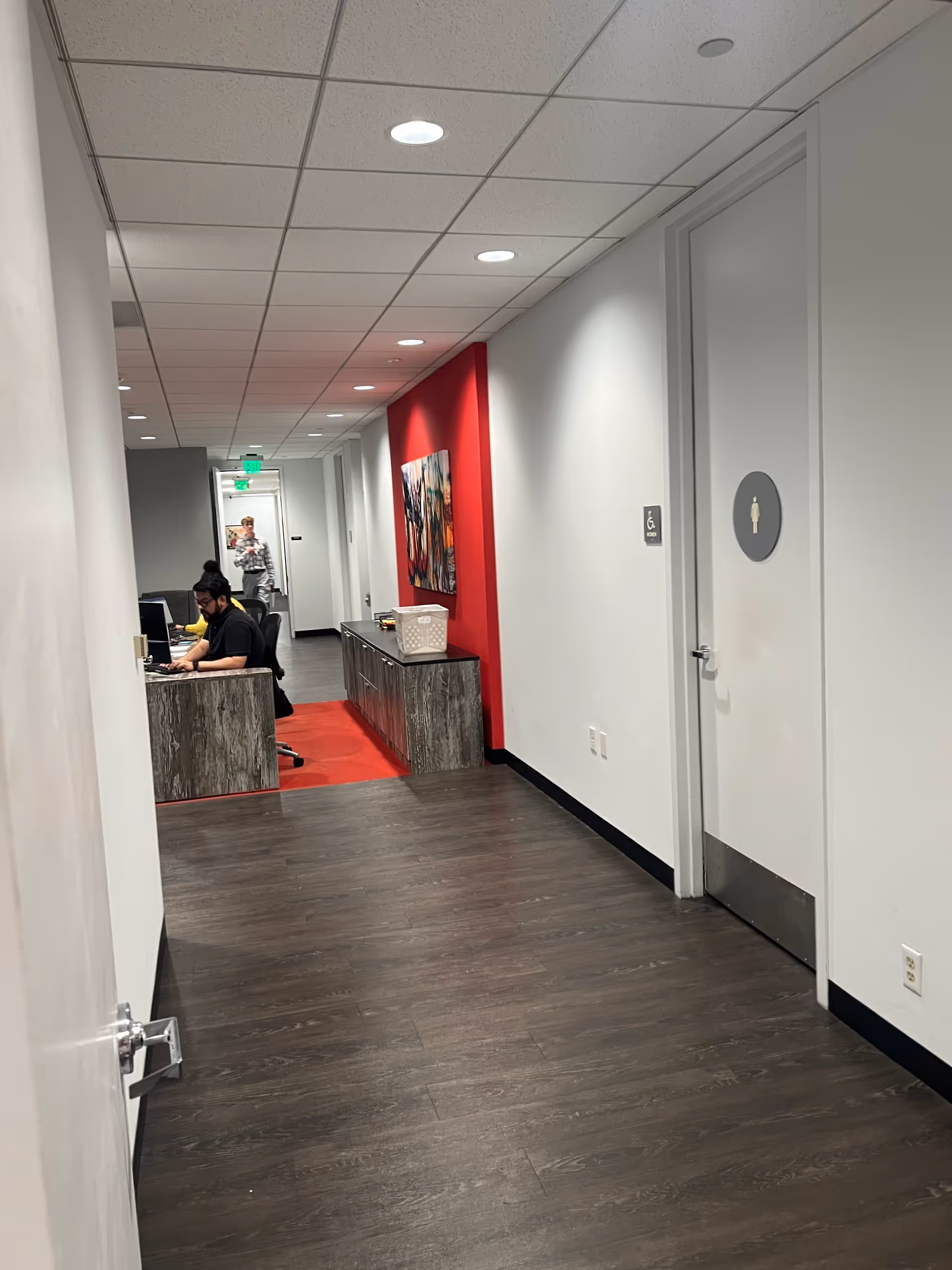 Interior hallway of a senior facility featuring a reception desk and staff at computers.