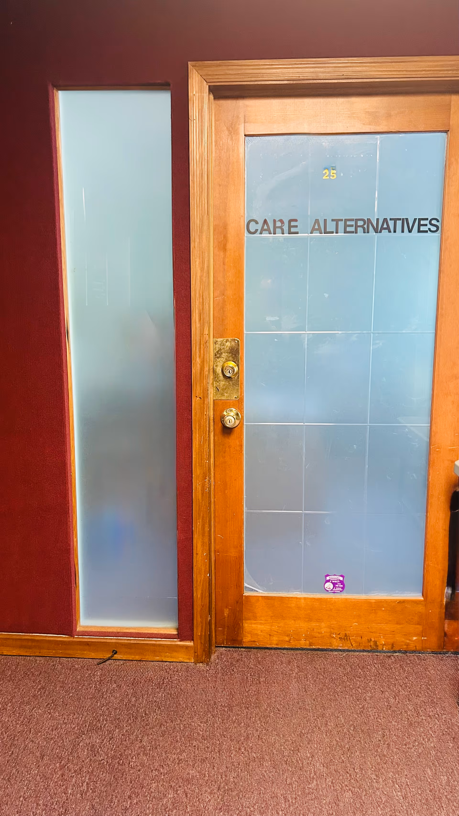 Interior hallway with a wooden-framed door labeled Care Alternatives.