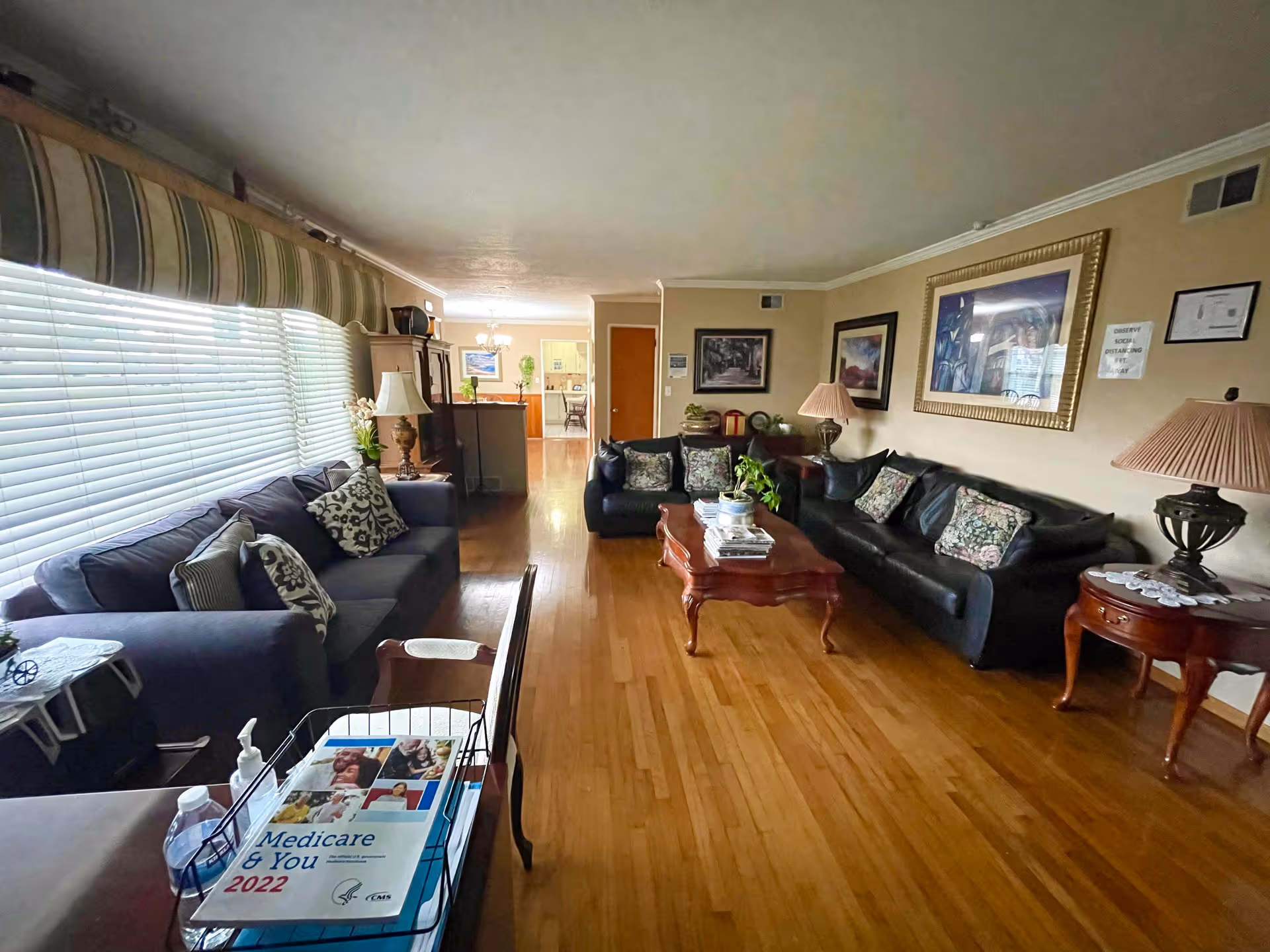A spacious living room in Violet Residential Care with couches, coffee table, and art.