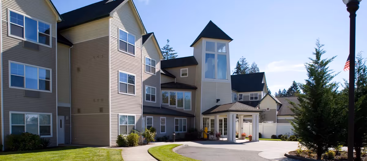 Exterior view of Avamere at Hillsboro with multi-story beige building and entrance canopy.