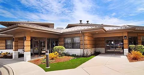 Front entrance of Alden Courts and Gardens of Des Plaines, with brick exterior and landscaped walkway.