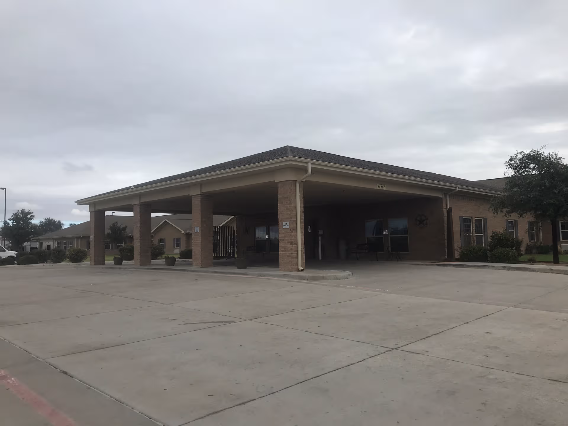 Exterior view of Windmill Village Rehabilitation and Care Center entrance with a covered drop-off area.