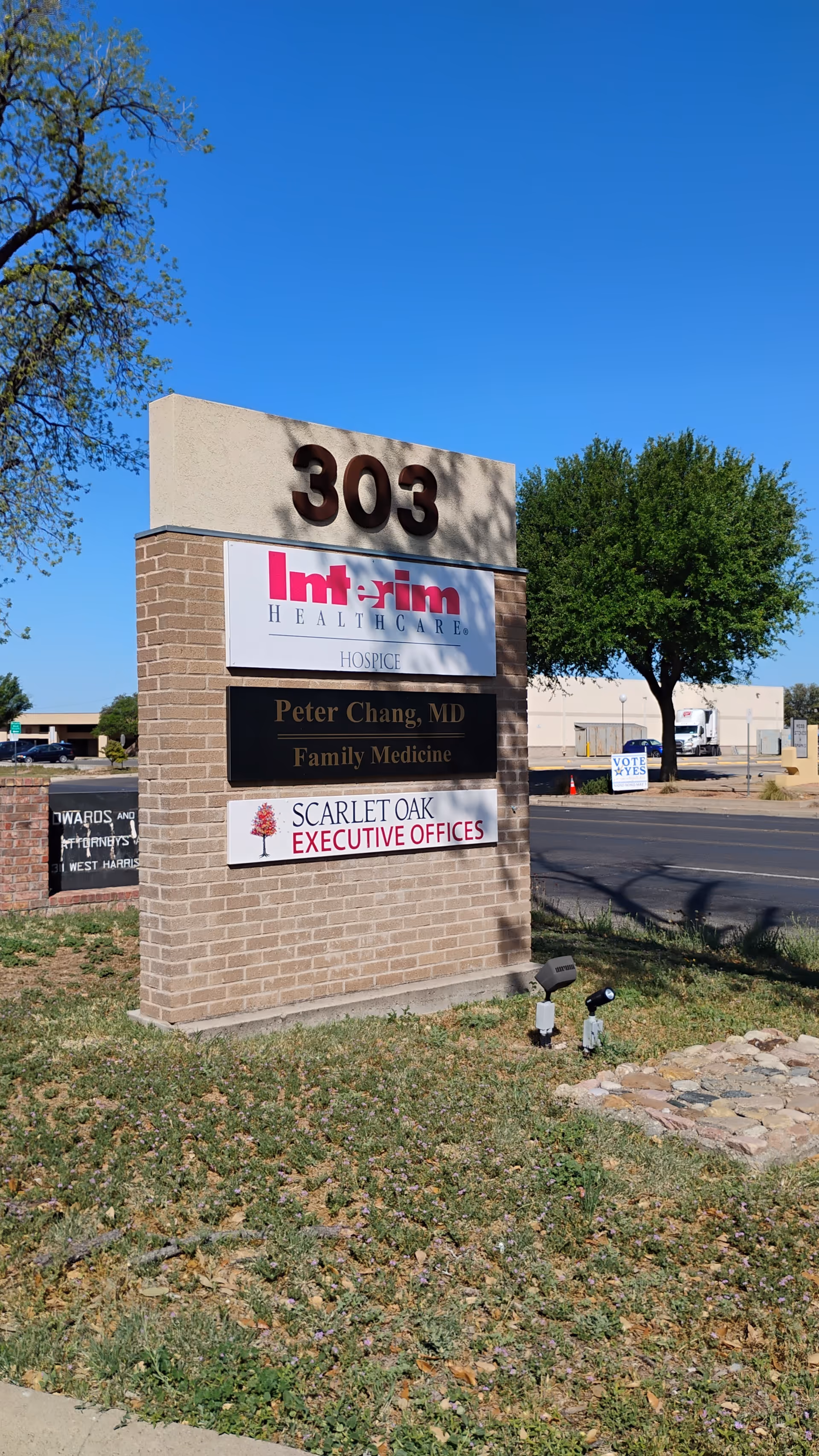 Brick sign at the building front shows Interim HealthCare Hospice and executive offices.
