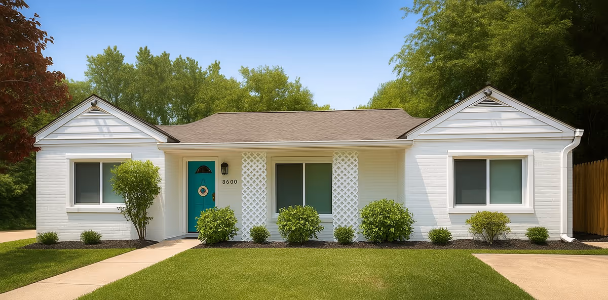 White single-story building with a teal front door and manicured landscaping.