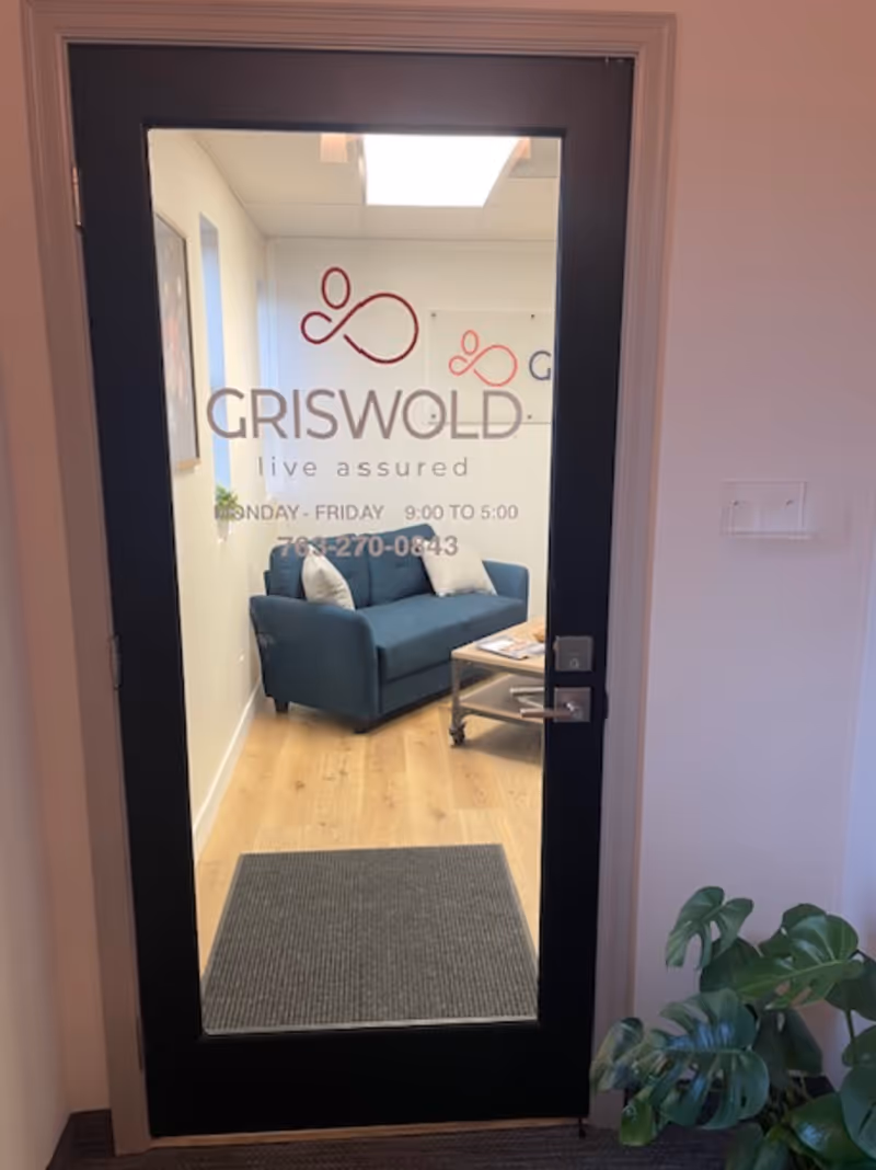 Glass door shows Griswold logo; leads into a small blue sofa lounge area.