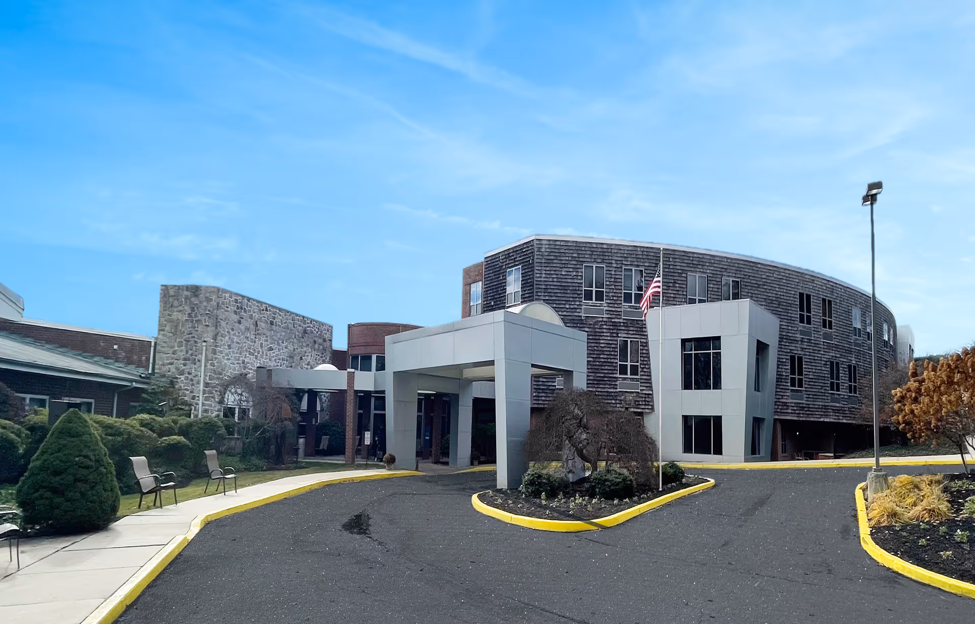 Exterior view of Springfield Crossings senior living facility with curved entrance and parking lot.