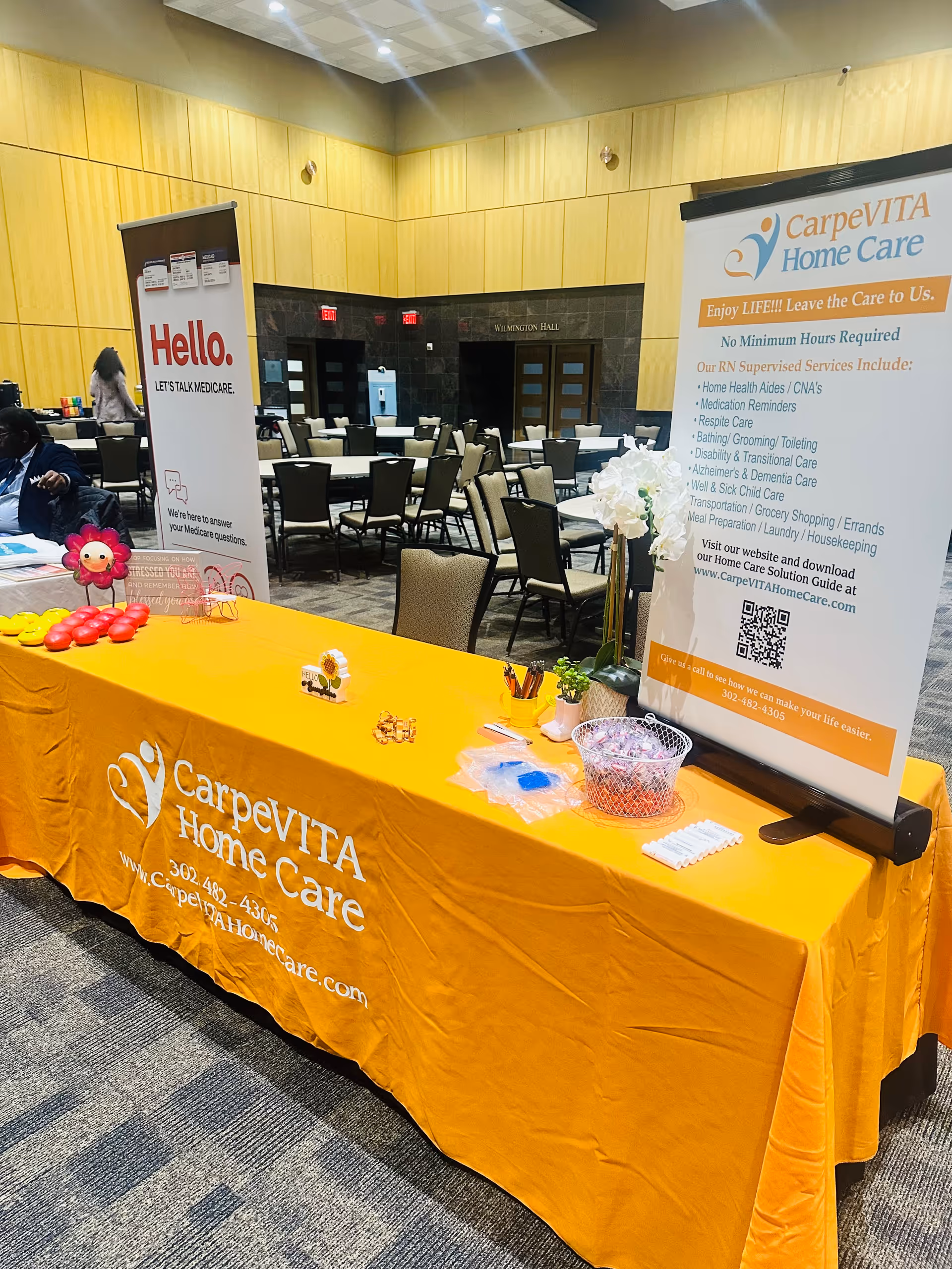 Promotional booth for CarpeVITA Home Care at an indoor event with banners and tables