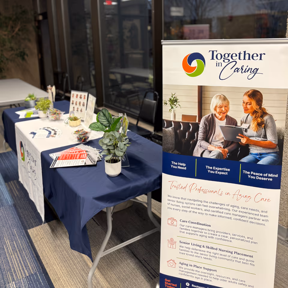 Indoor lobby with an information booth and a Together in Caring banner.