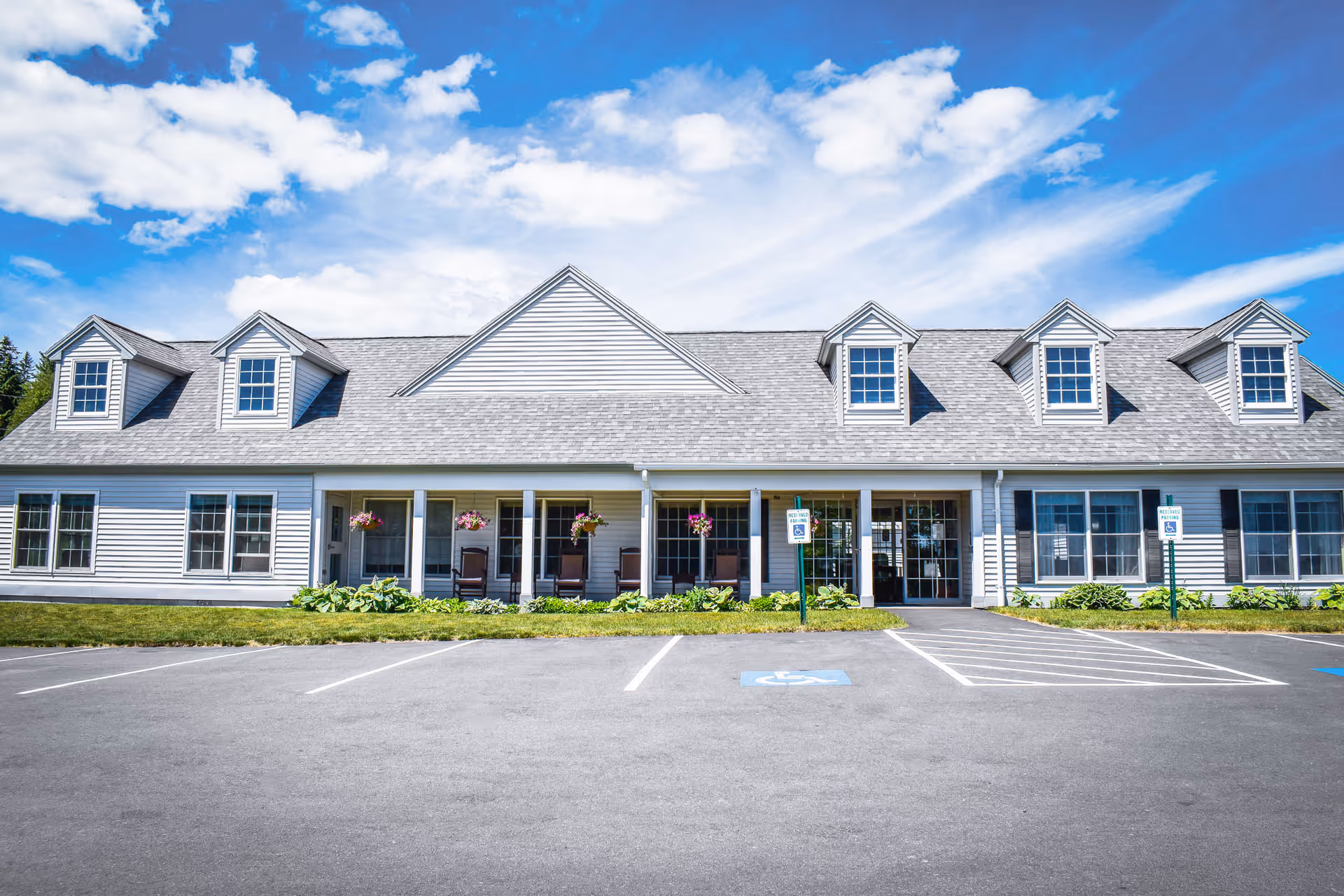 Front exterior of Pleasant Meadows Estates senior living building with a parking area.