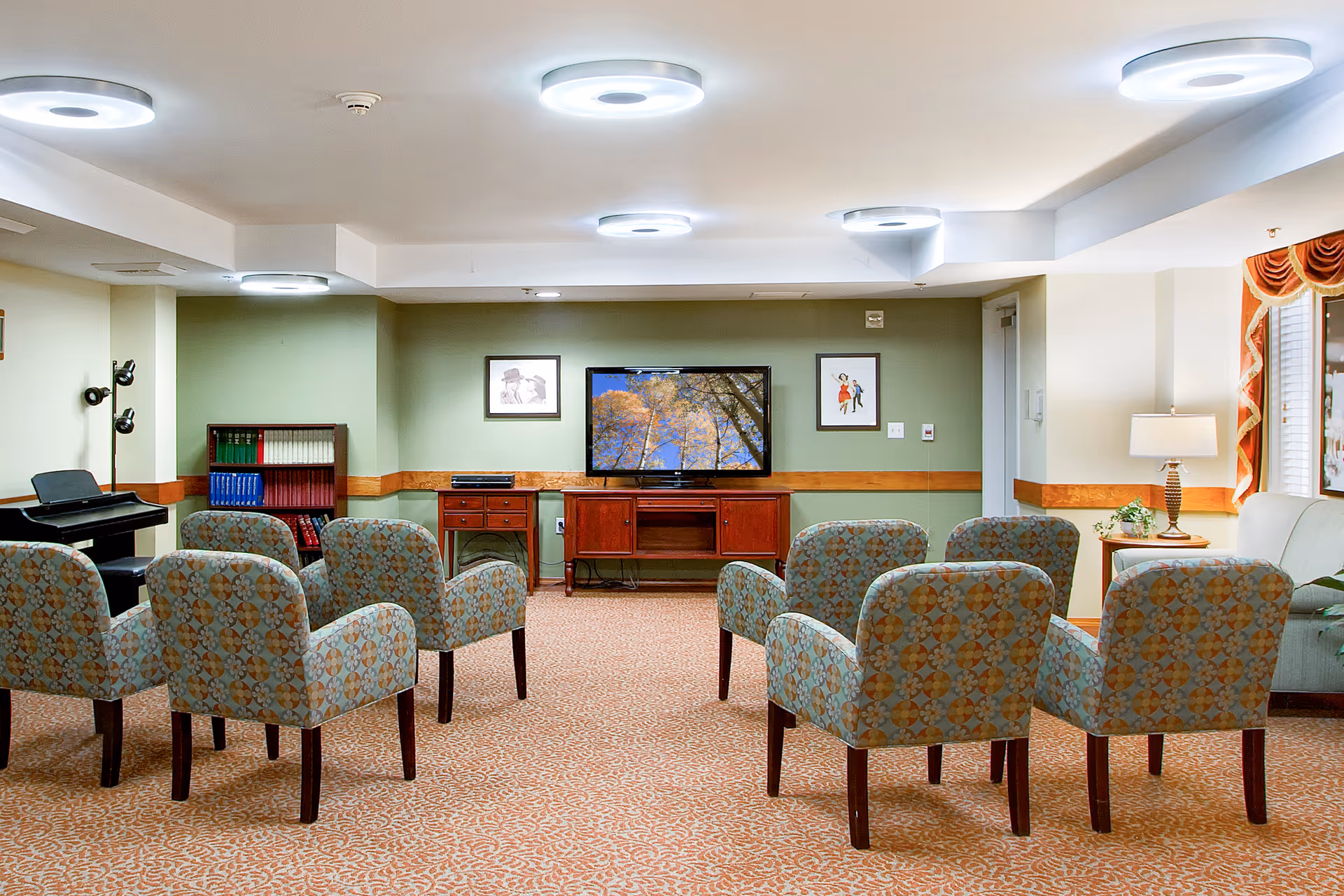 Lounge area in Brookdale Montclair Poulsbo with patterned chairs and a TV.