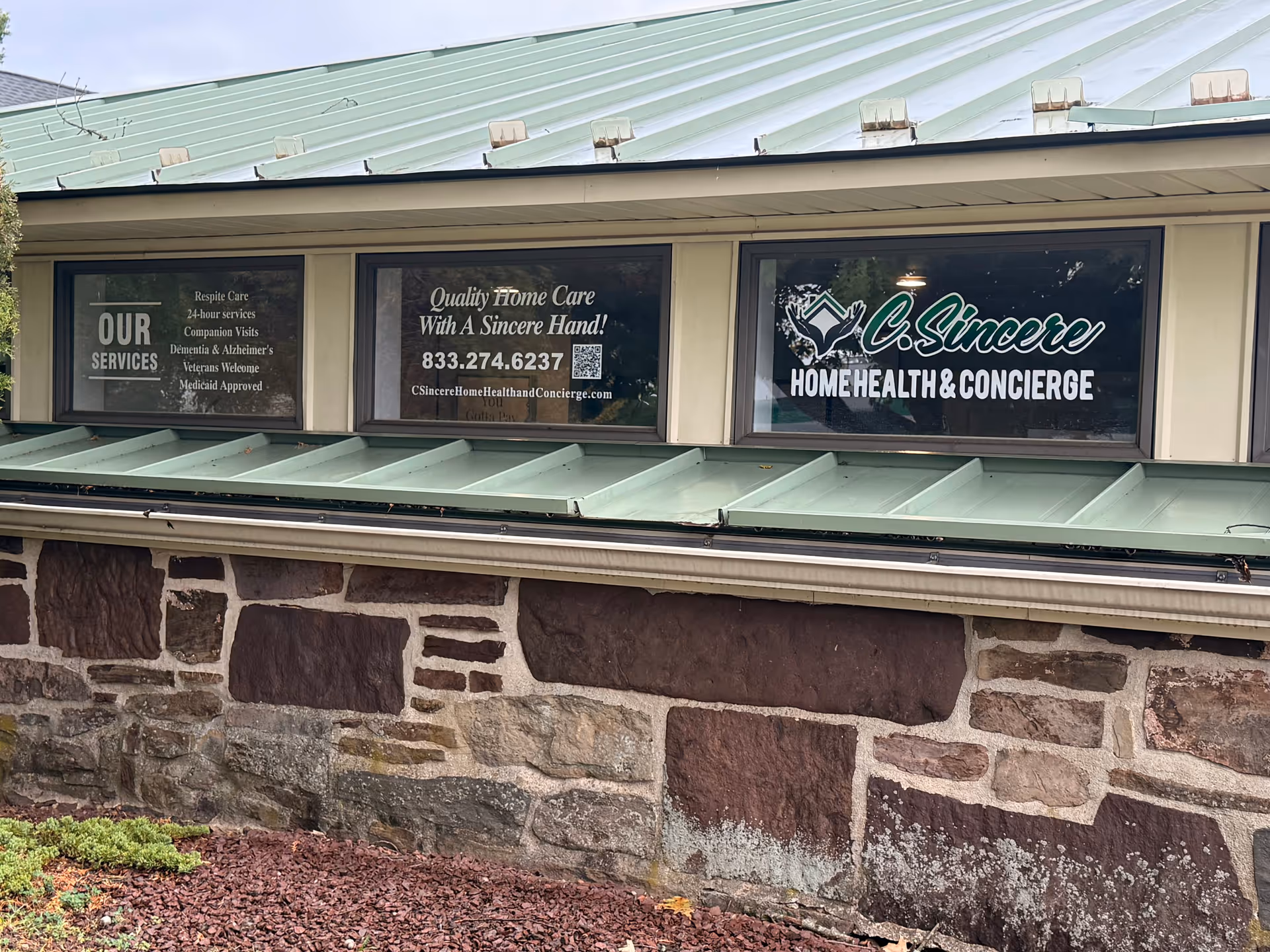 Exterior view of a stone building with three windows displaying 'C Sincere Home Health & Concierge'.