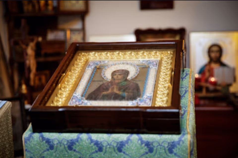 Framed religious icon on a green cloth-covered table inside an interior room