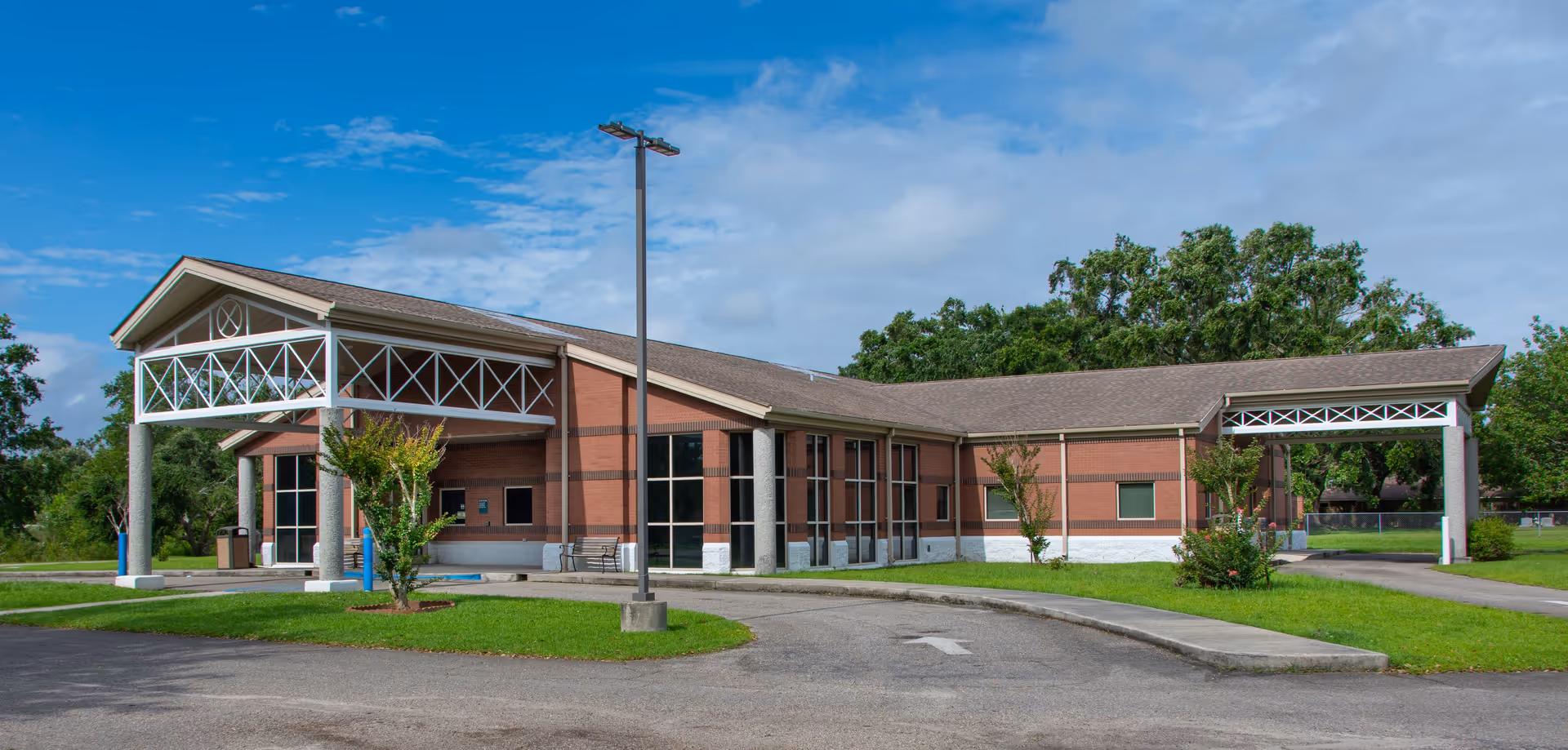 Brick medical clinic building with a covered entrance and manicured lawn.