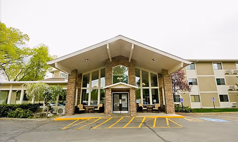 Exterior view of Williamsburg Retirement Community entrance with large glass facade.