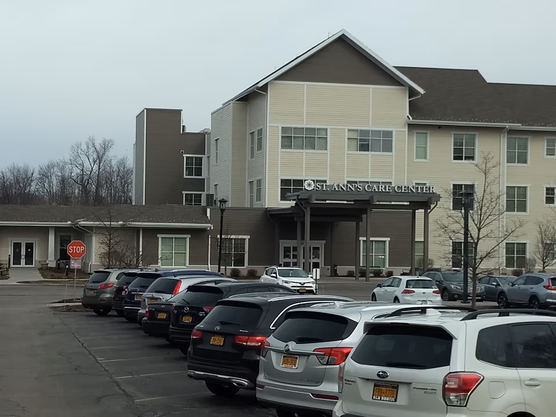 Front view of St. Ann's Care Center, with parked cars in a spacious lot.