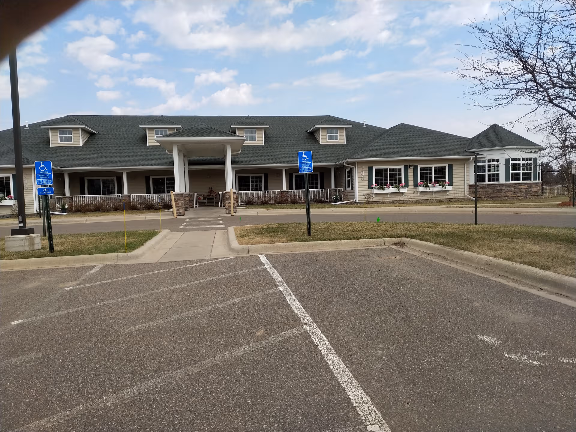 Exterior view of Prairie Senior Cottages with parking, entrance, and accessible walkway.