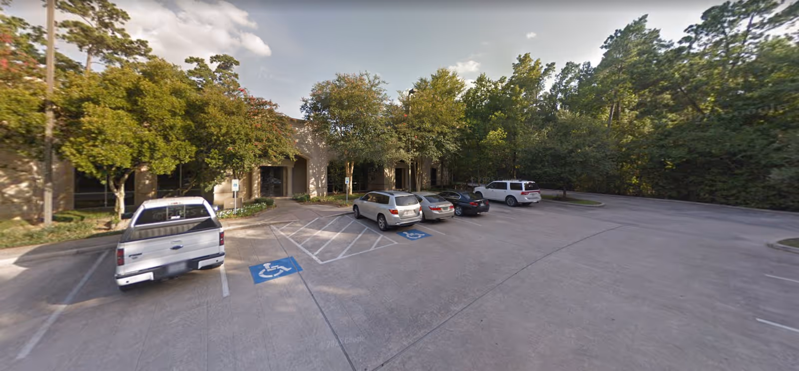 Exterior view of a parking lot and entrance to AvistaCare Health Care Services facility.